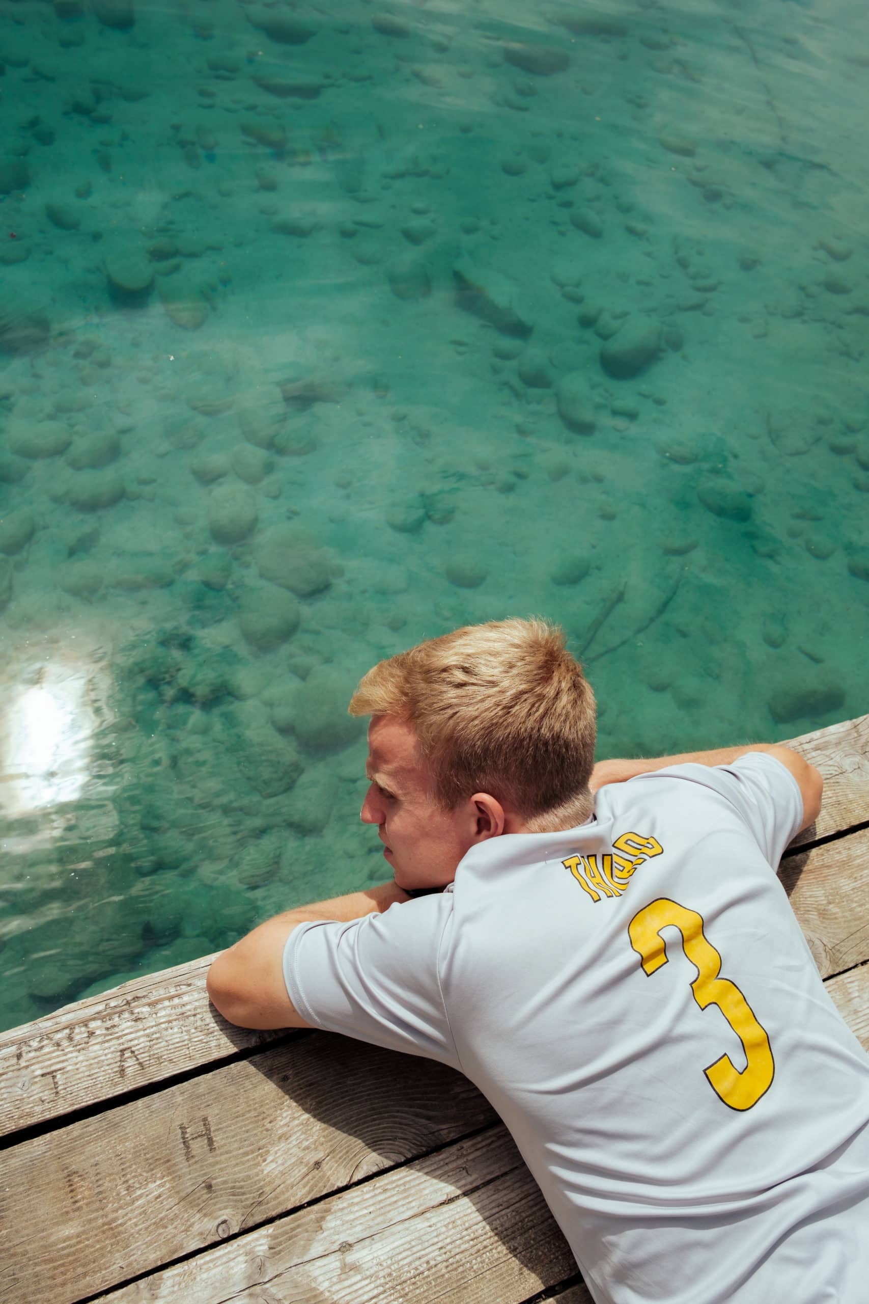A man lays on a platform at Lake Annette.