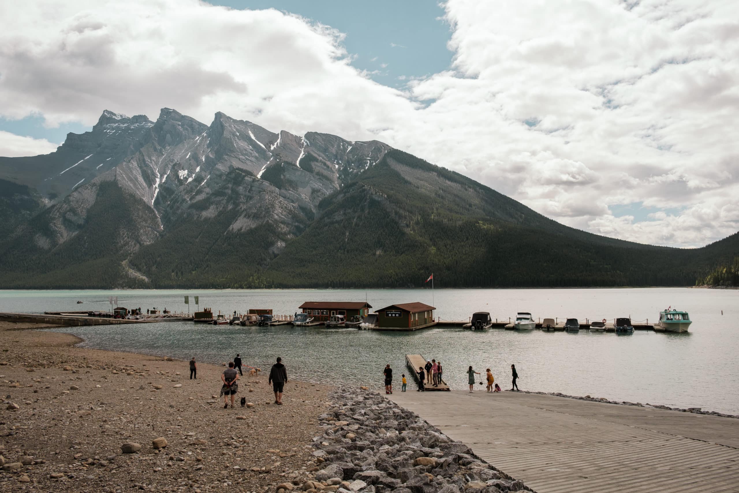 People walk along the edge of a lake.