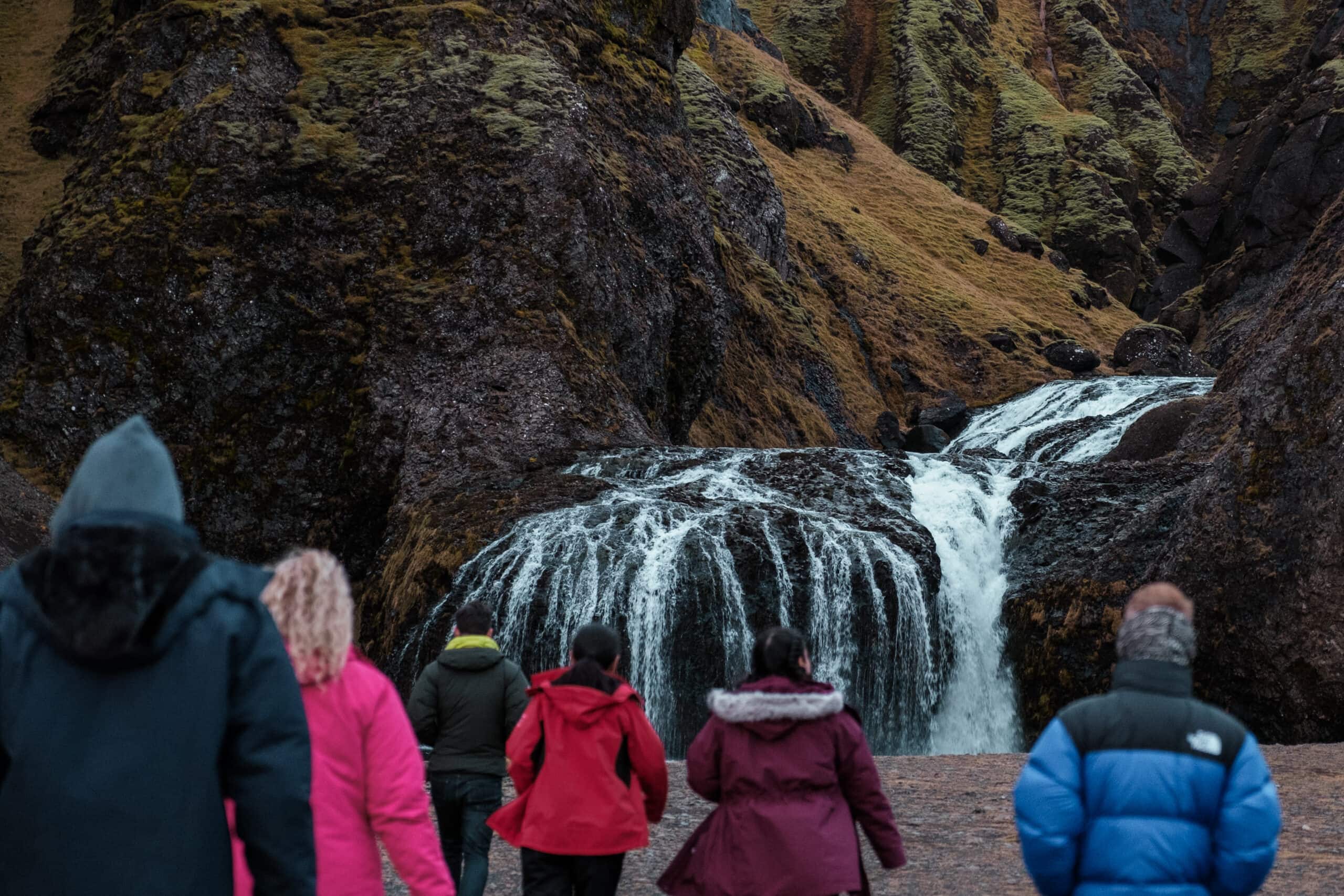 People walk toward Stjornarfoss.