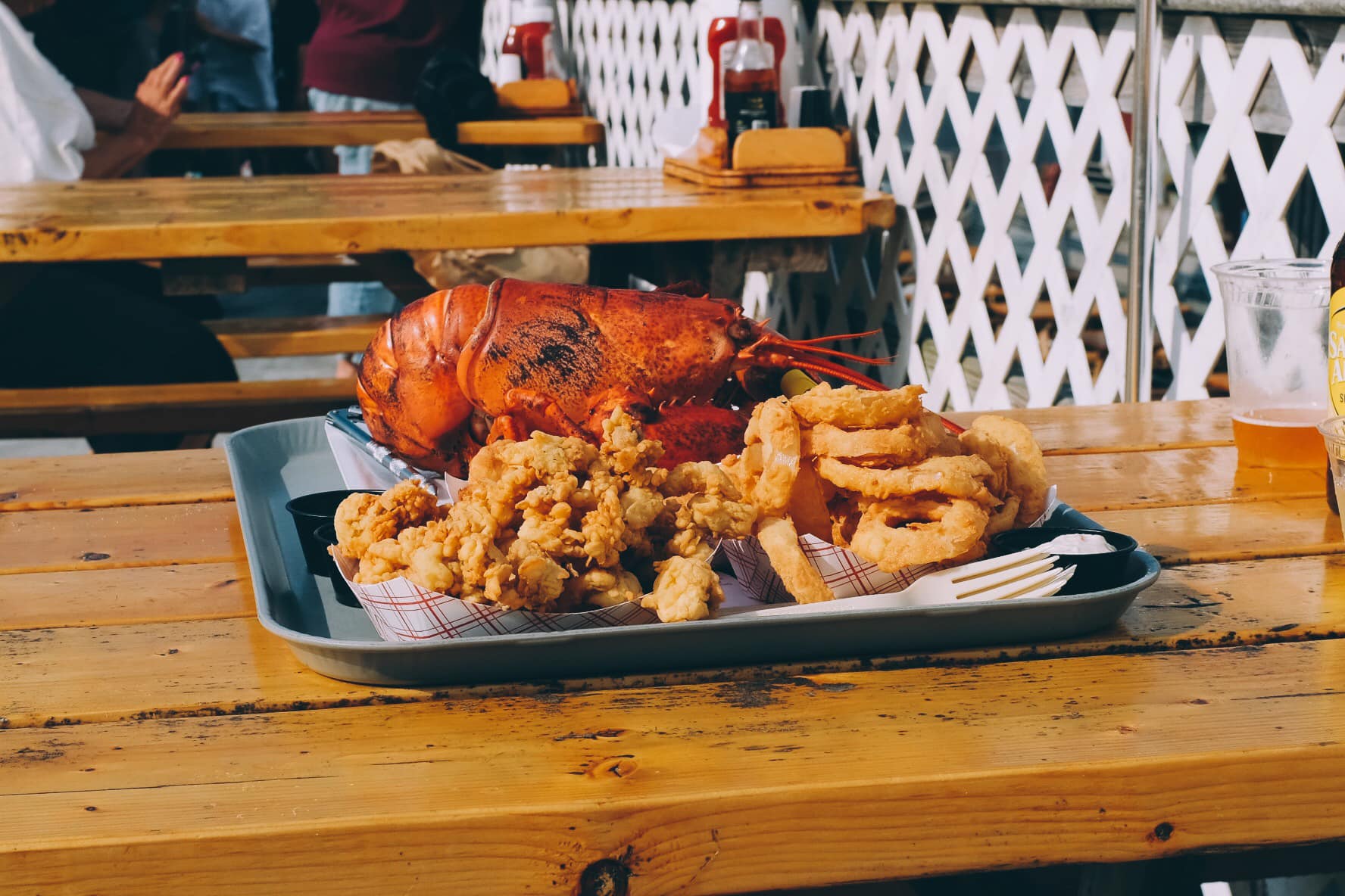 Lobster and other food on a tray.