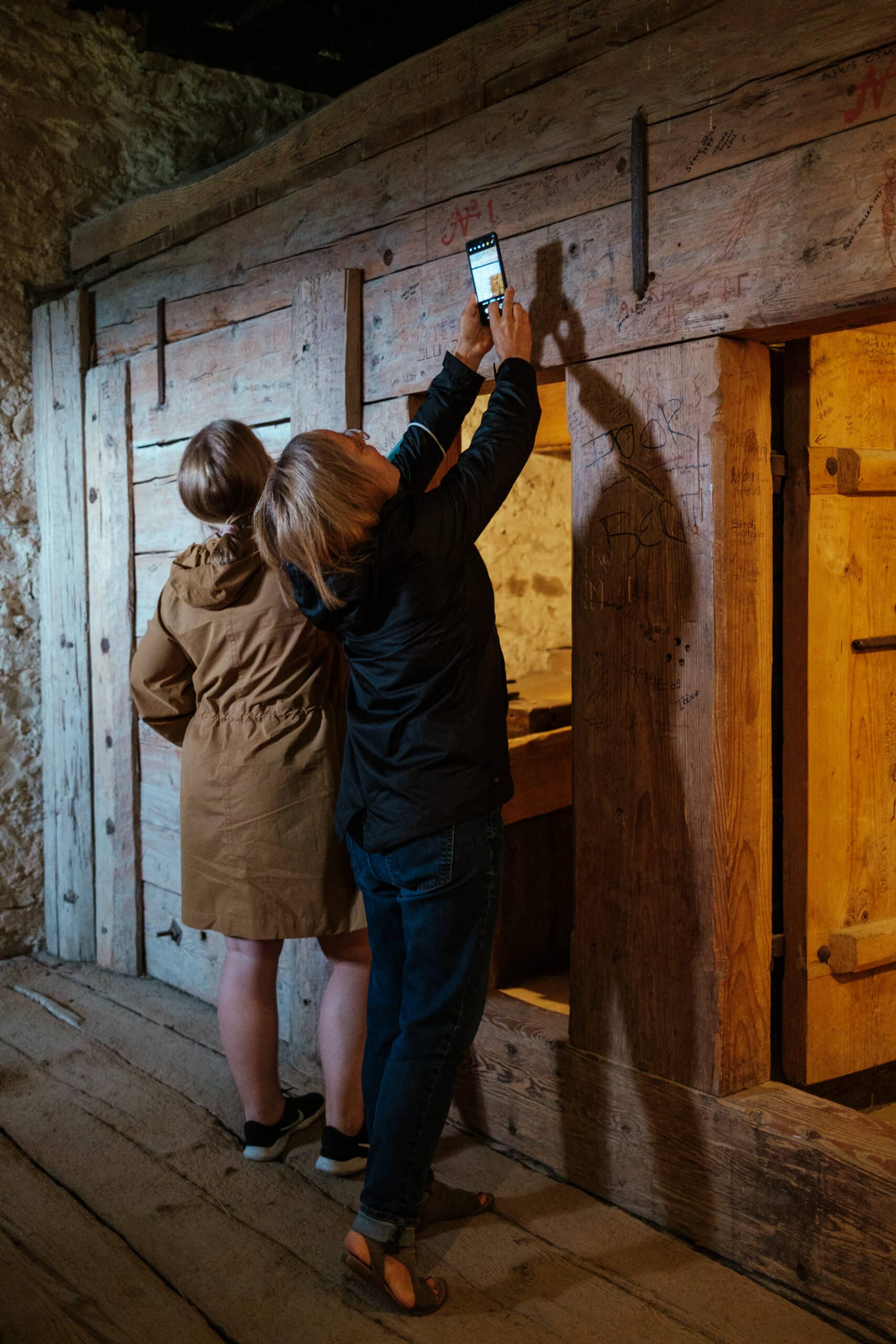 My mom takes a photo of names on the wall in Trachselwald Castle.