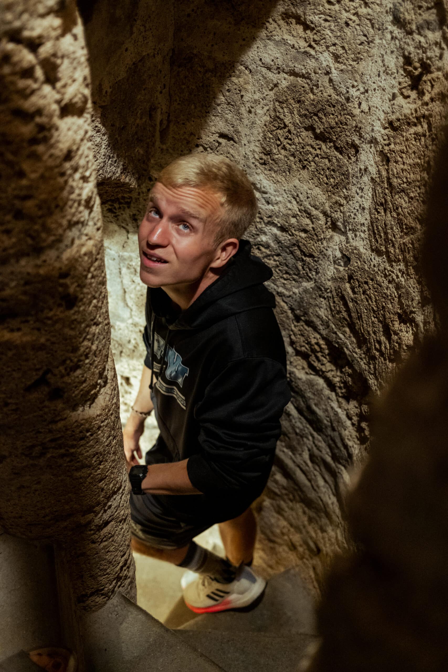 A man walks down narrow stairs in Trachselwald Castle.