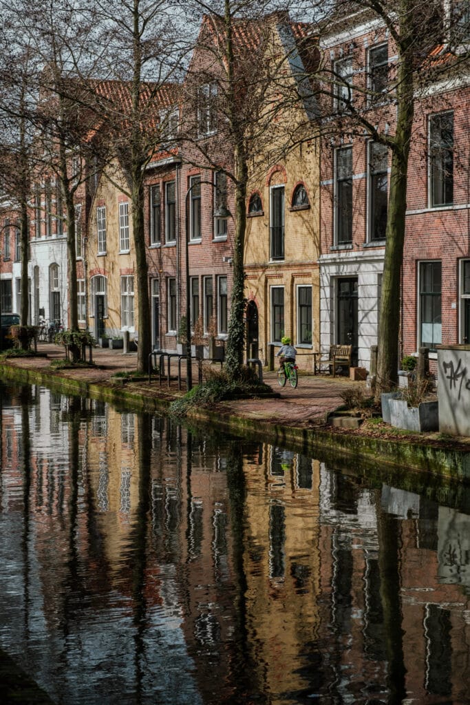 A child rides a bike beside a canal in Delft.