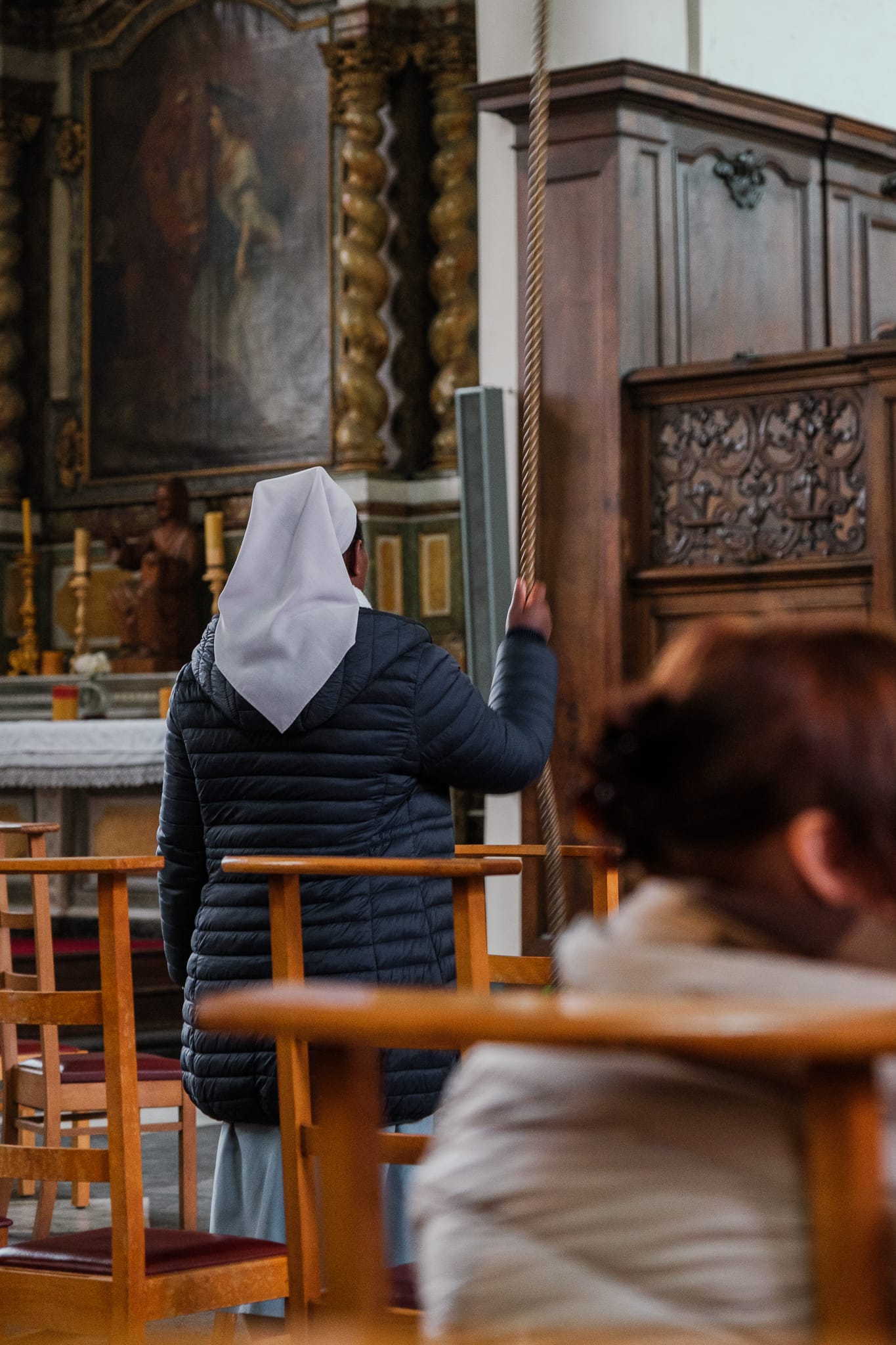 A nun rings the bell inside the Begijnhof's chapel.