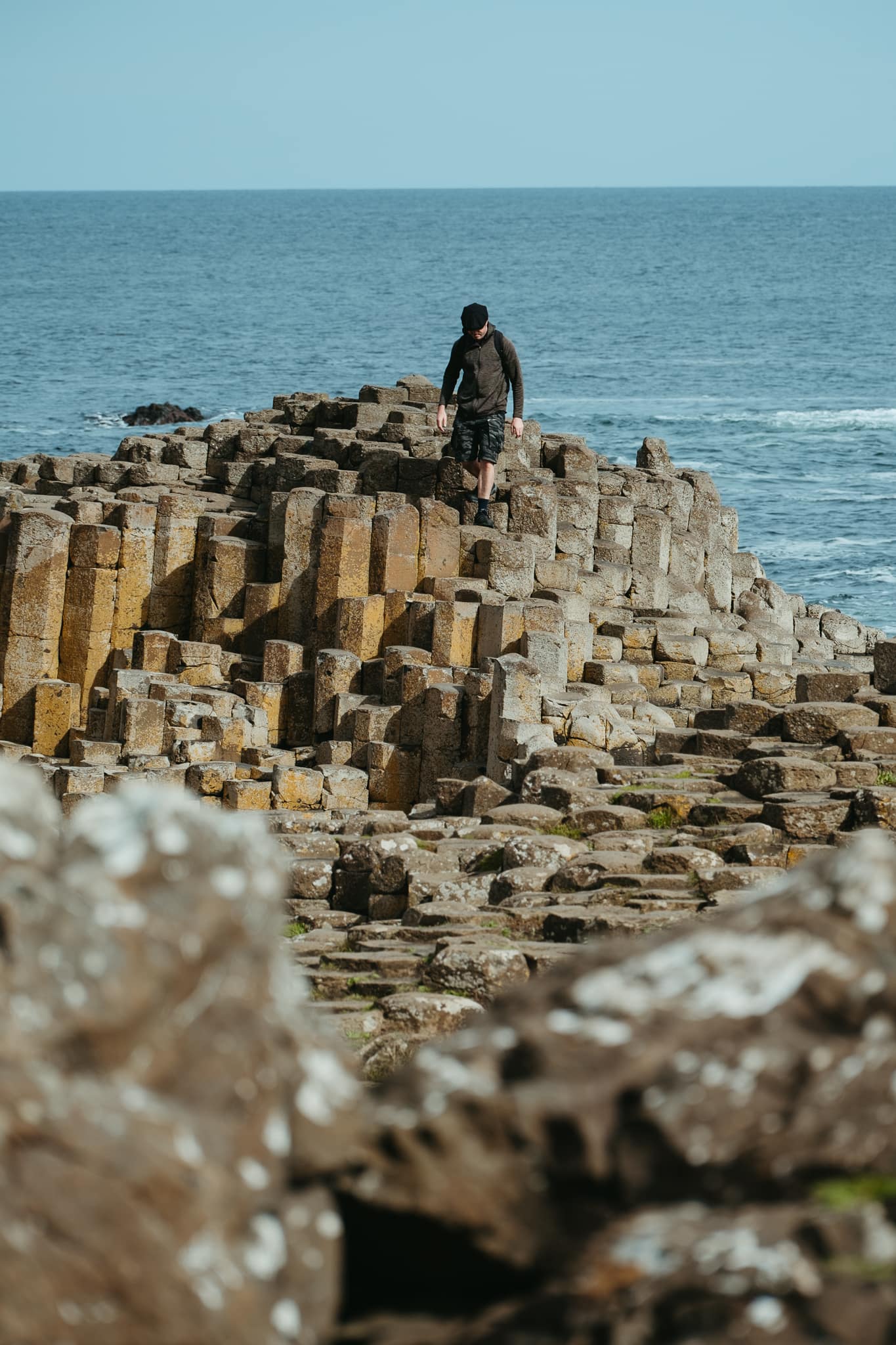 A man climbs on cascading basalt columns at Giant's Causeway.