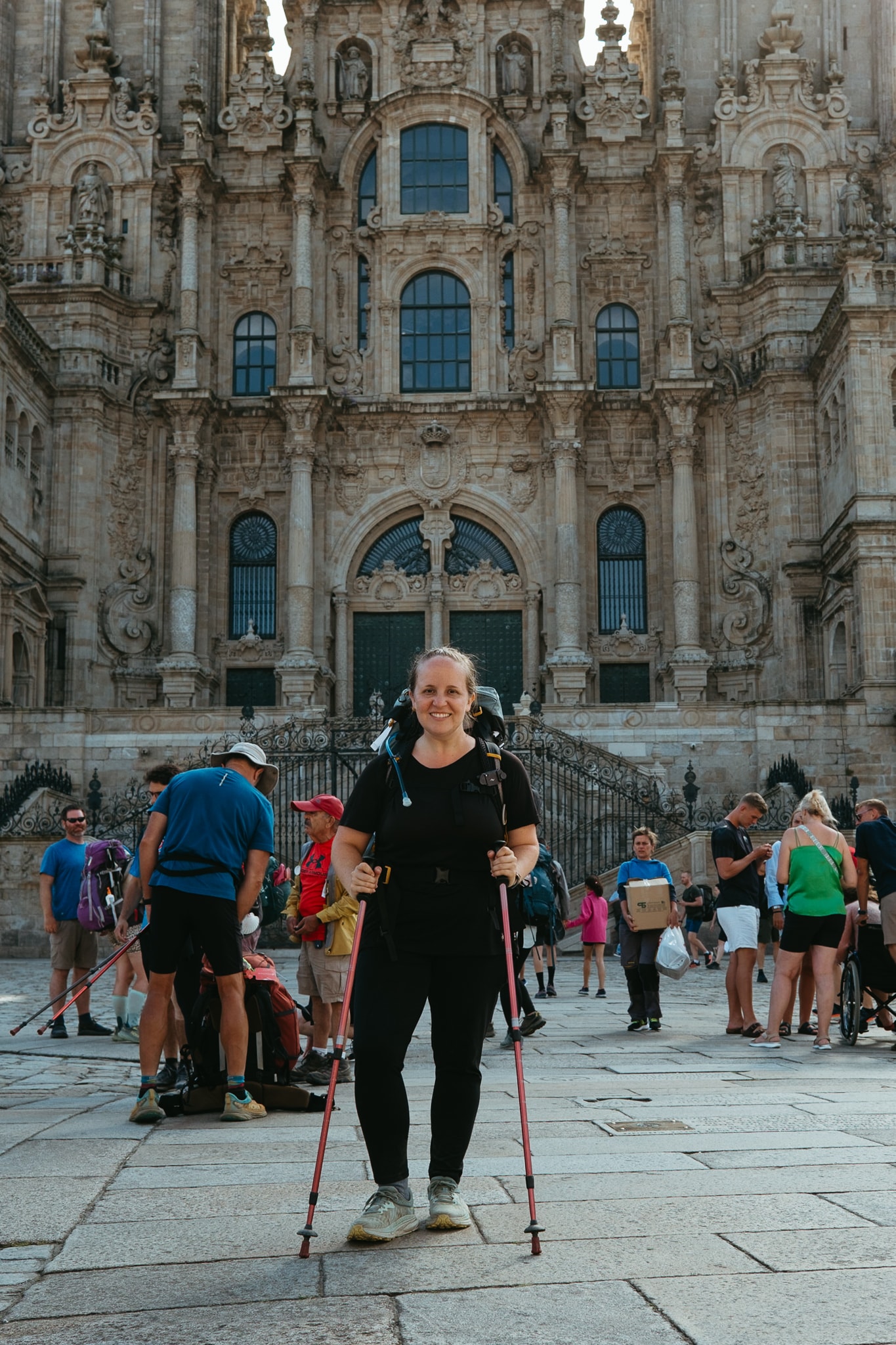 A pilgrim (me!) poses in front of the Santiago de Compostela cathedral.