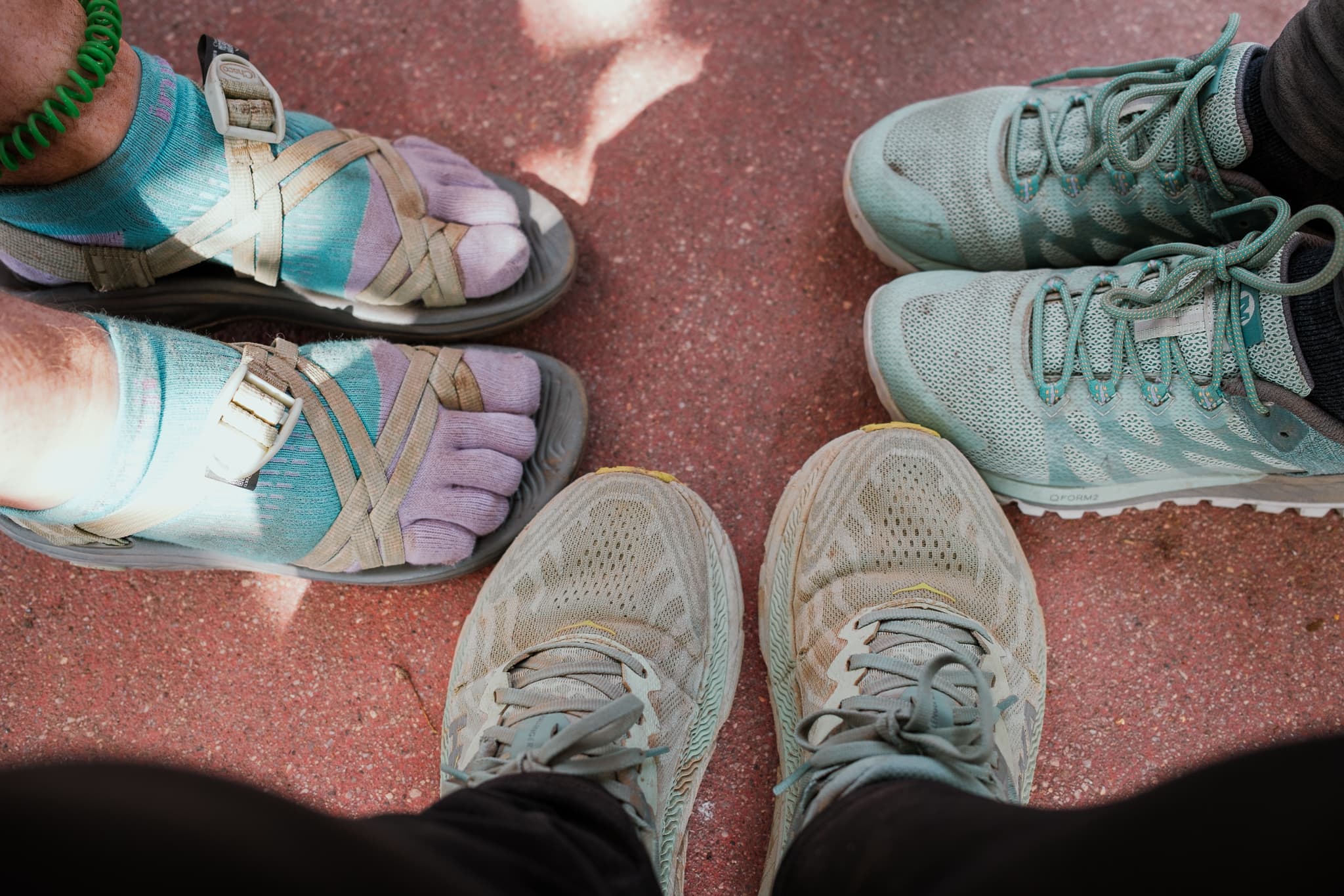 Two dirty pairs of shoes and one dirty pair of sandals.