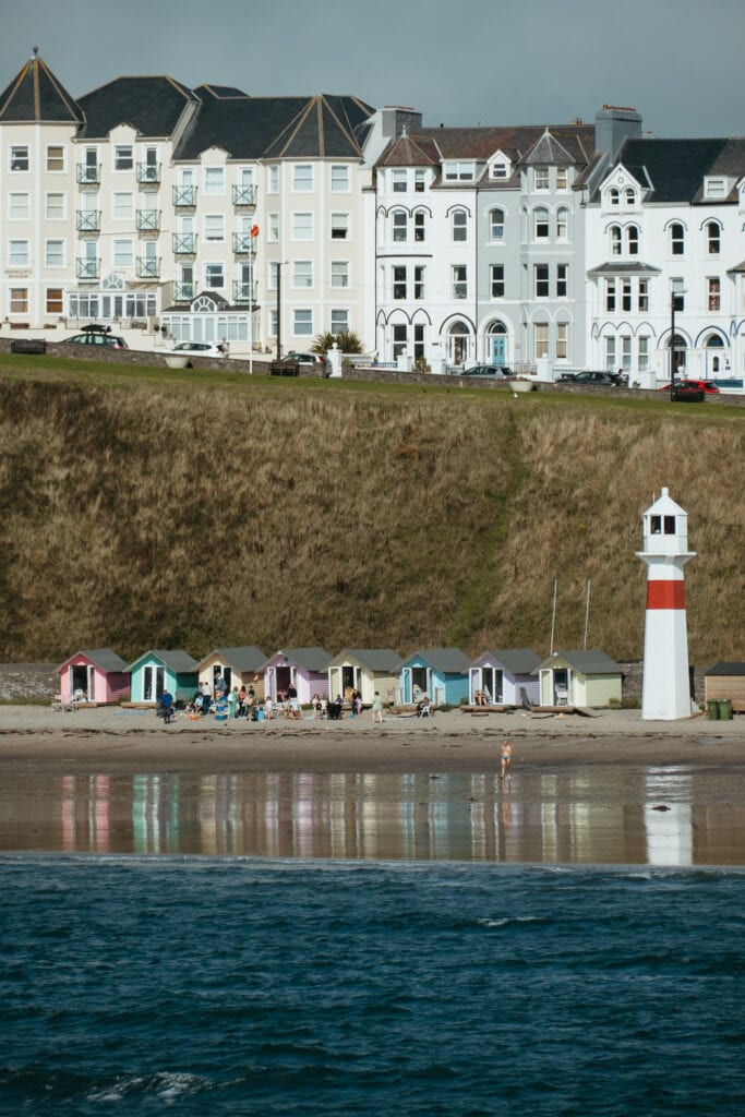 Small, colorful buildings stand along the beach of Port Erin.