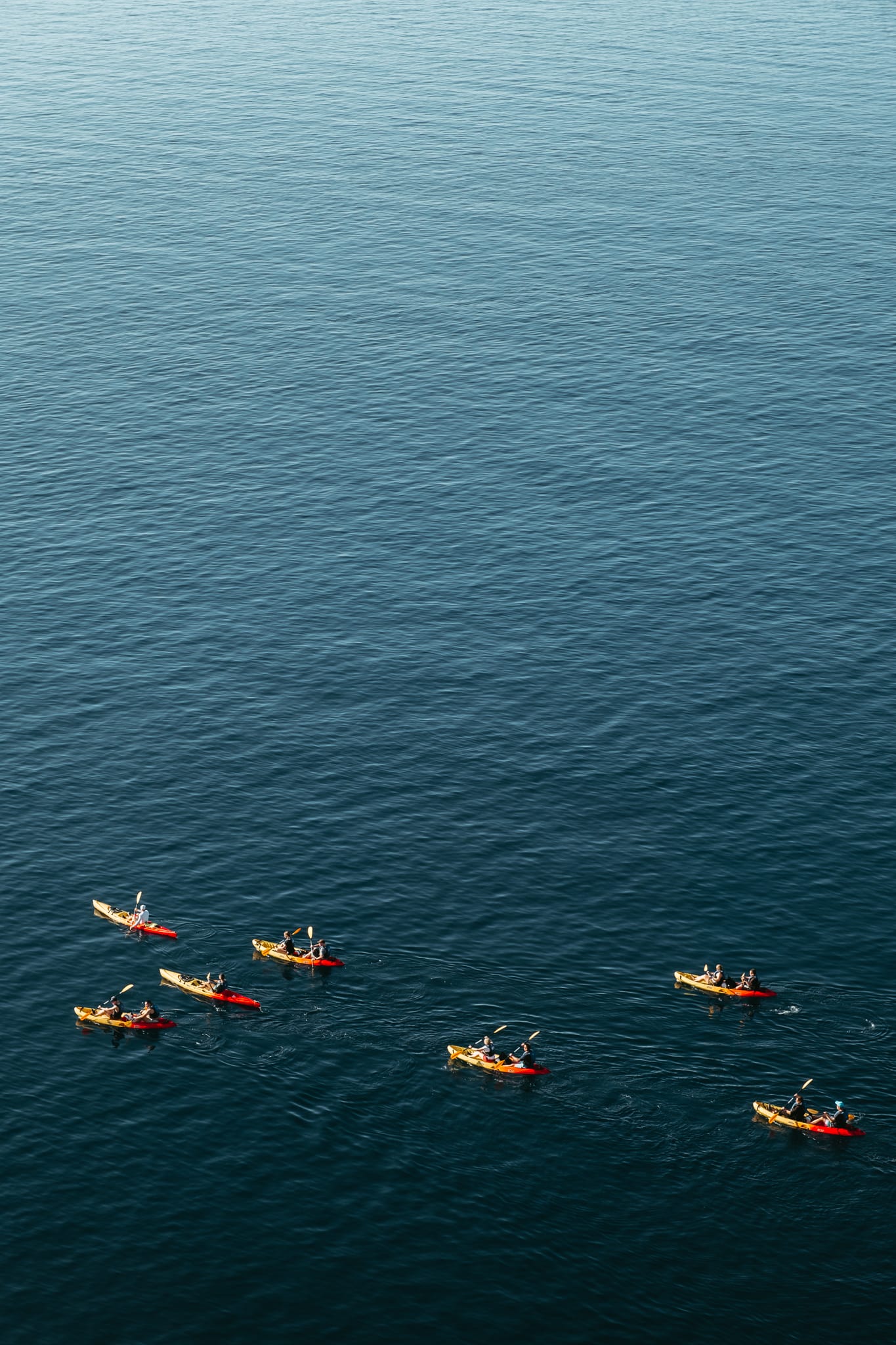 A group of kayaks in the water around Dubrovnik.