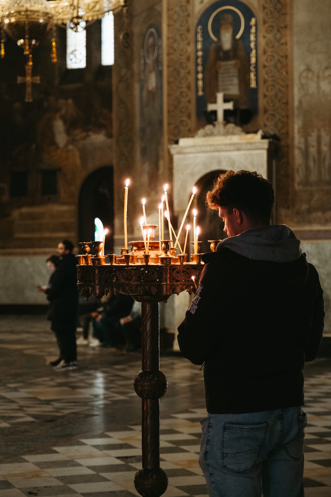 A man lights a candle inside a church in Sofia.