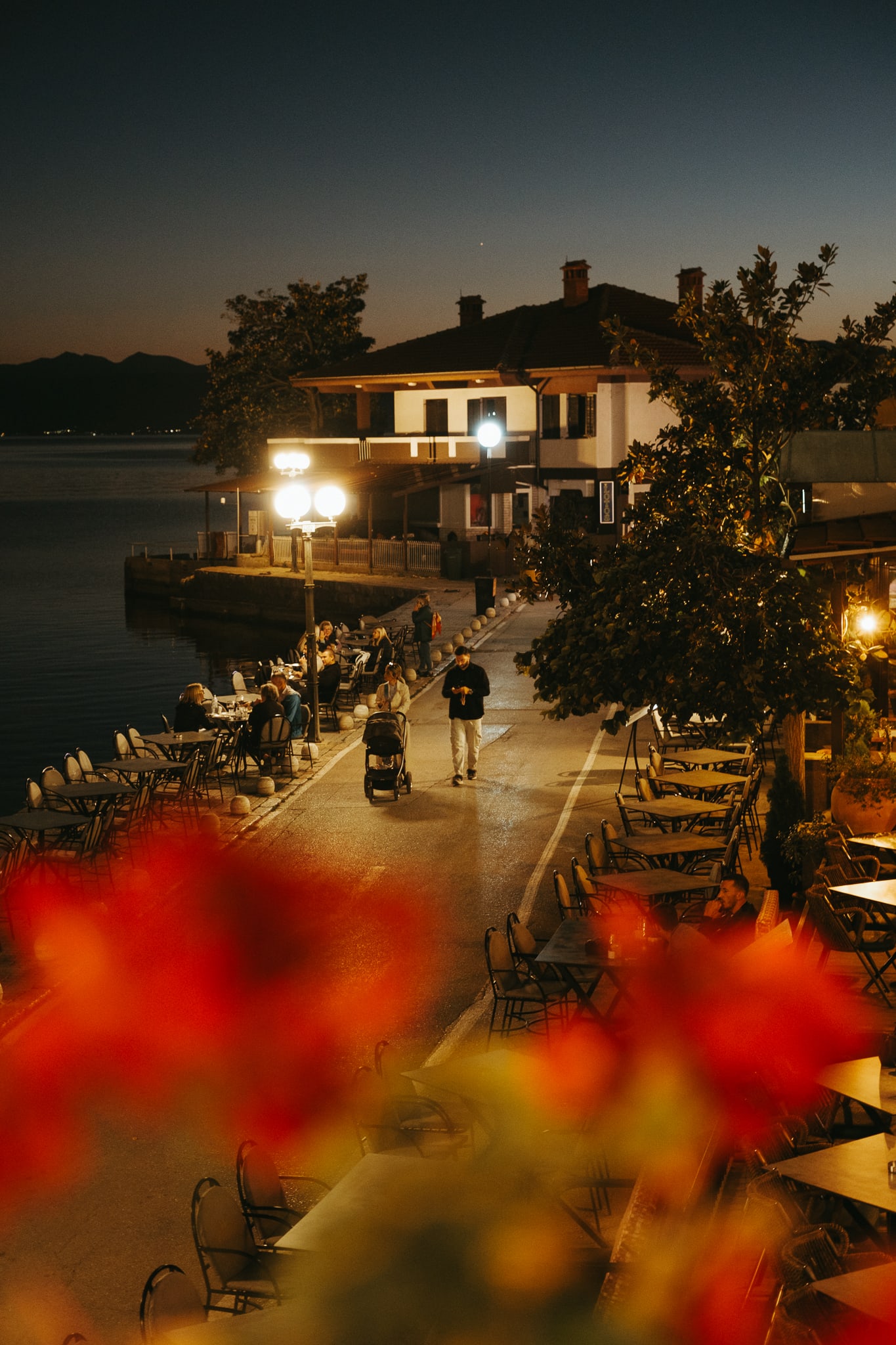 A family strolls along a street in Ohrid at night.