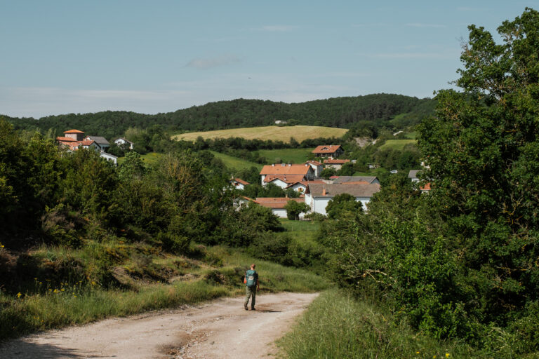 Lone pilgrim walking along a dirt path.