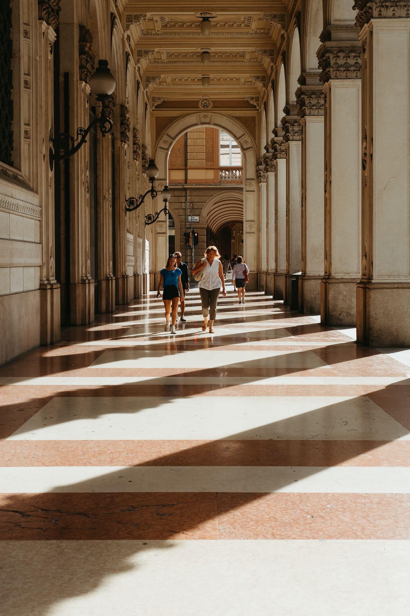 People walk through one of Bologna's many porticoes.