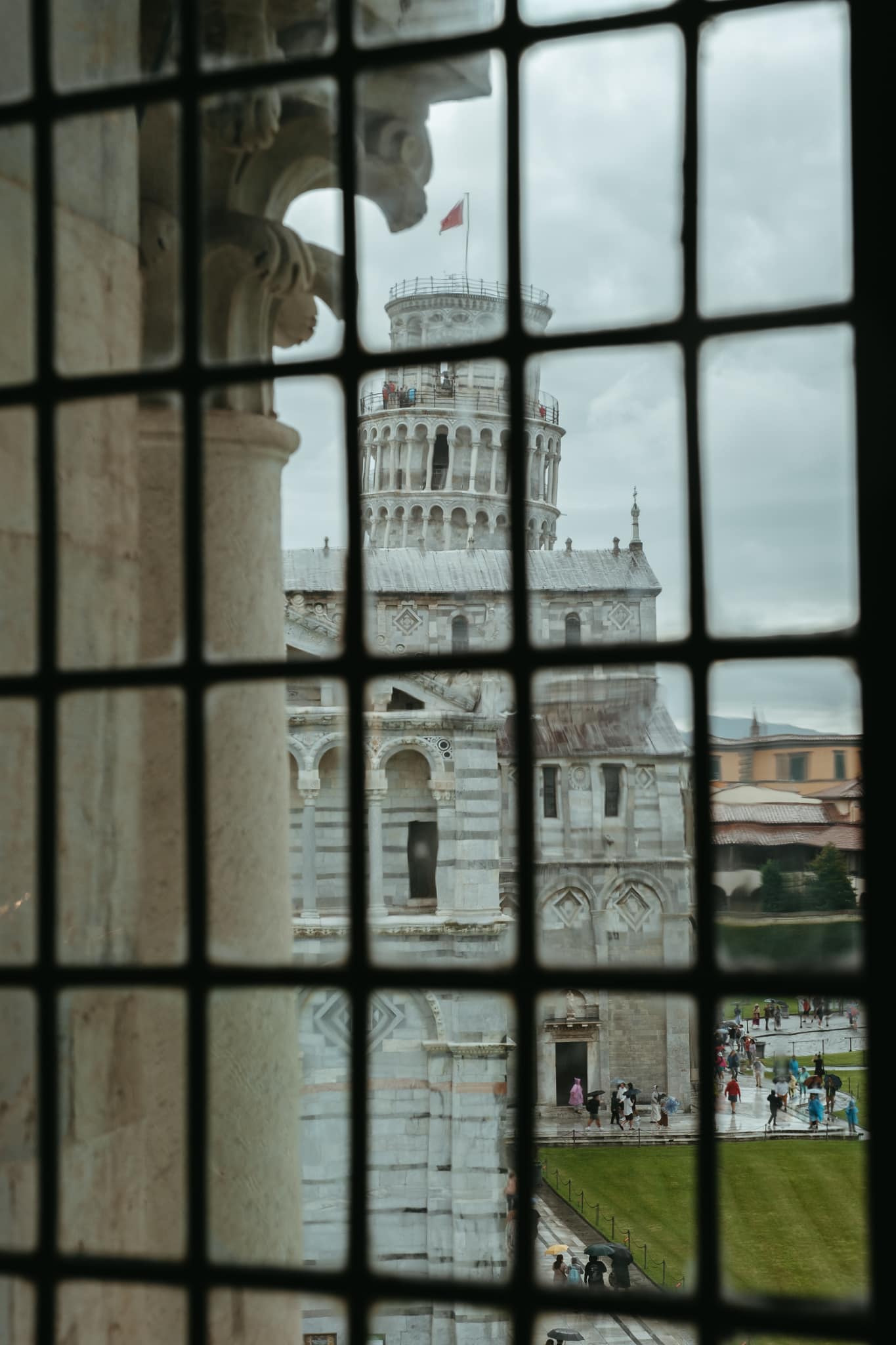 The Leaning Tower of Pisa, seen through a baptistery window.