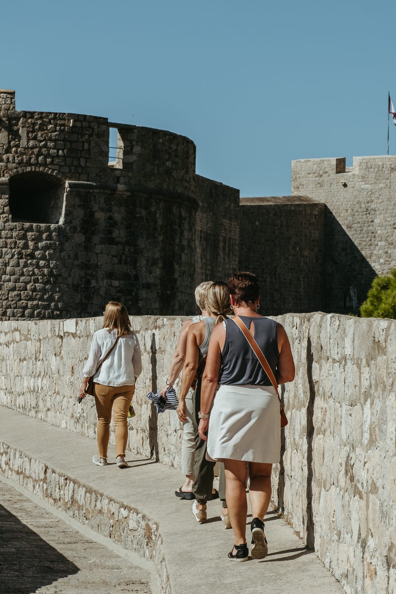 Women walk Dubrovnik's city walls.
