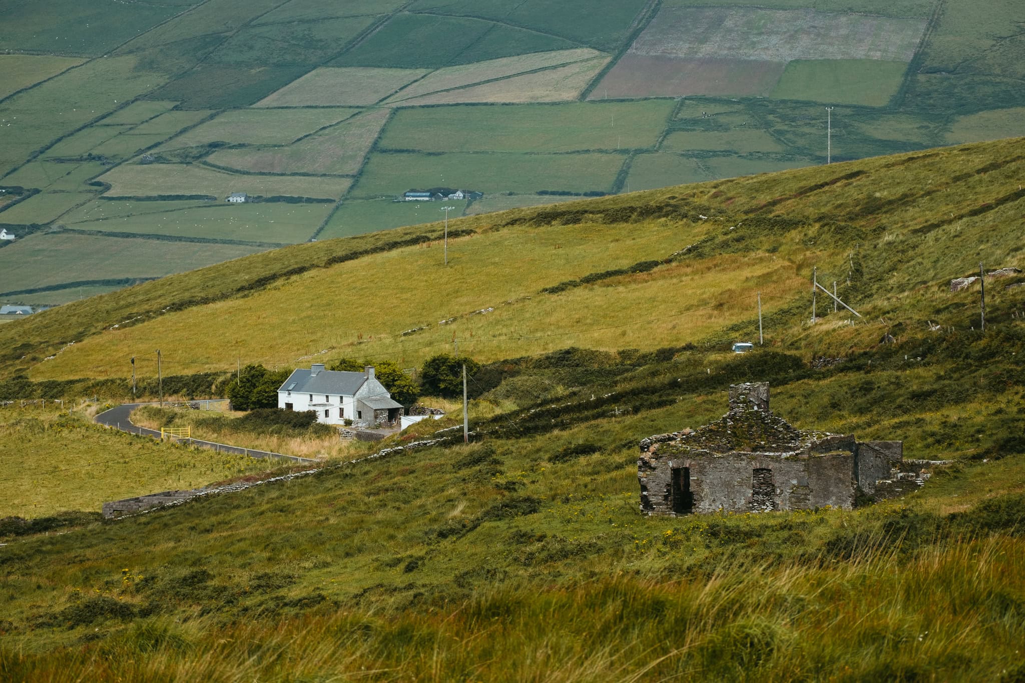 Old and new buildings sit in the midst of green Irish fields.