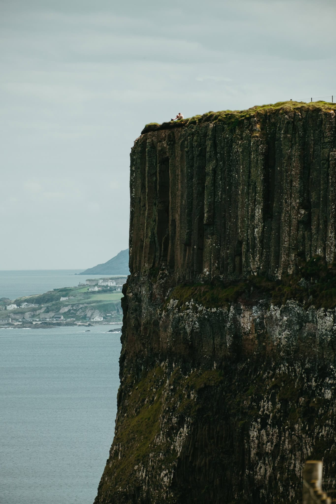 People standing atop a huge cliff on the Causeway Coast Way trail.