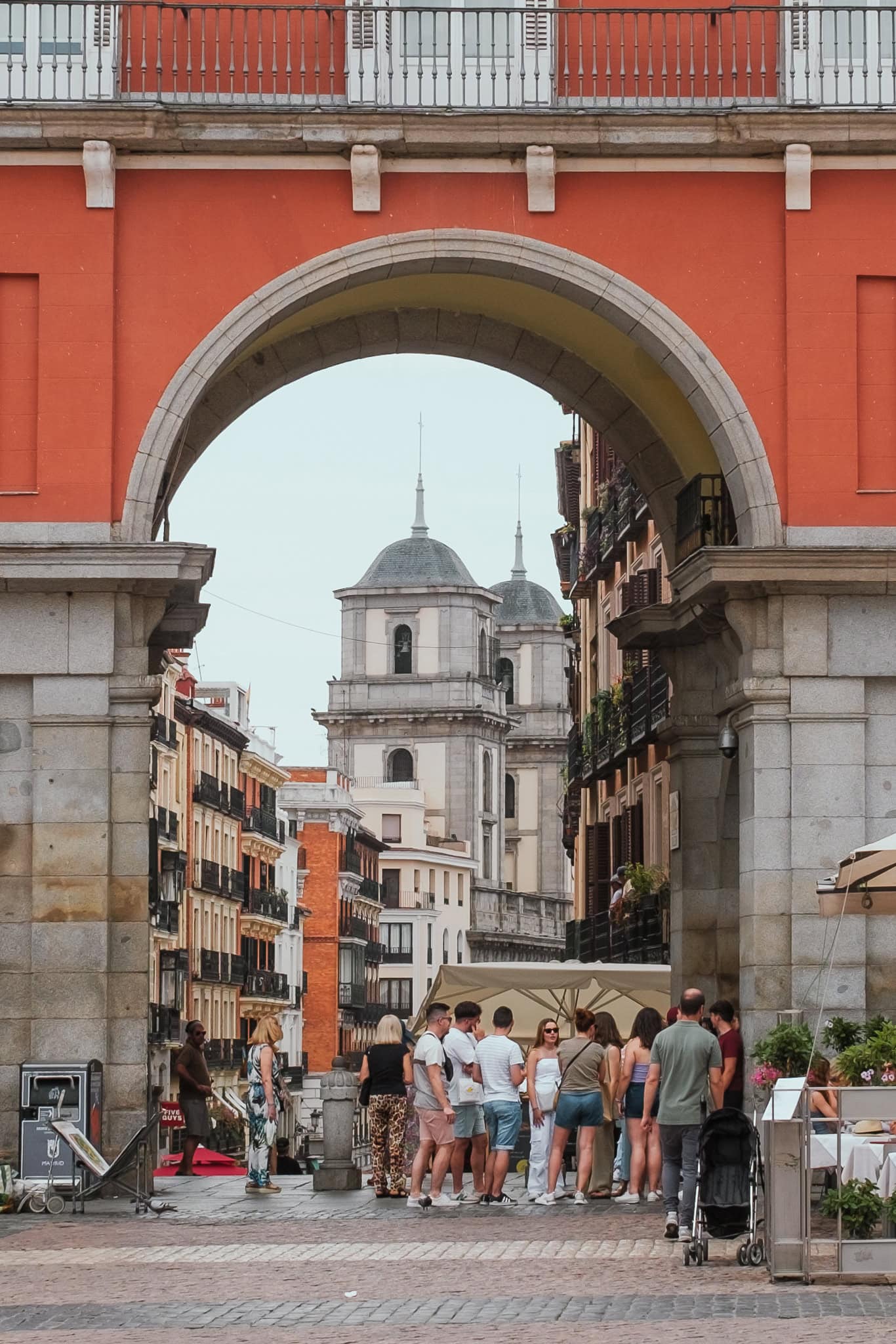 People stand under an arch in Plaza Mayor.