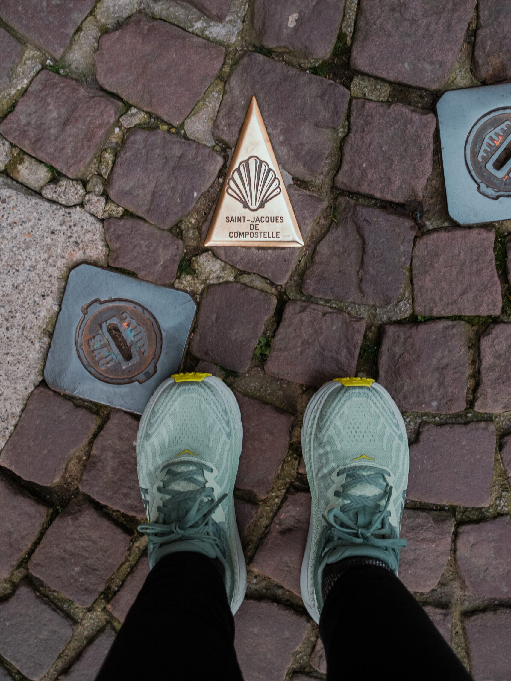 My feet standing beside a Camino road marker.