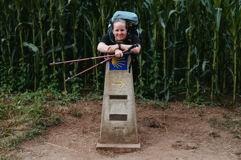 With my backpack on, I stand behind a pillar marking the last 10 kilometers of the Camino Frances.