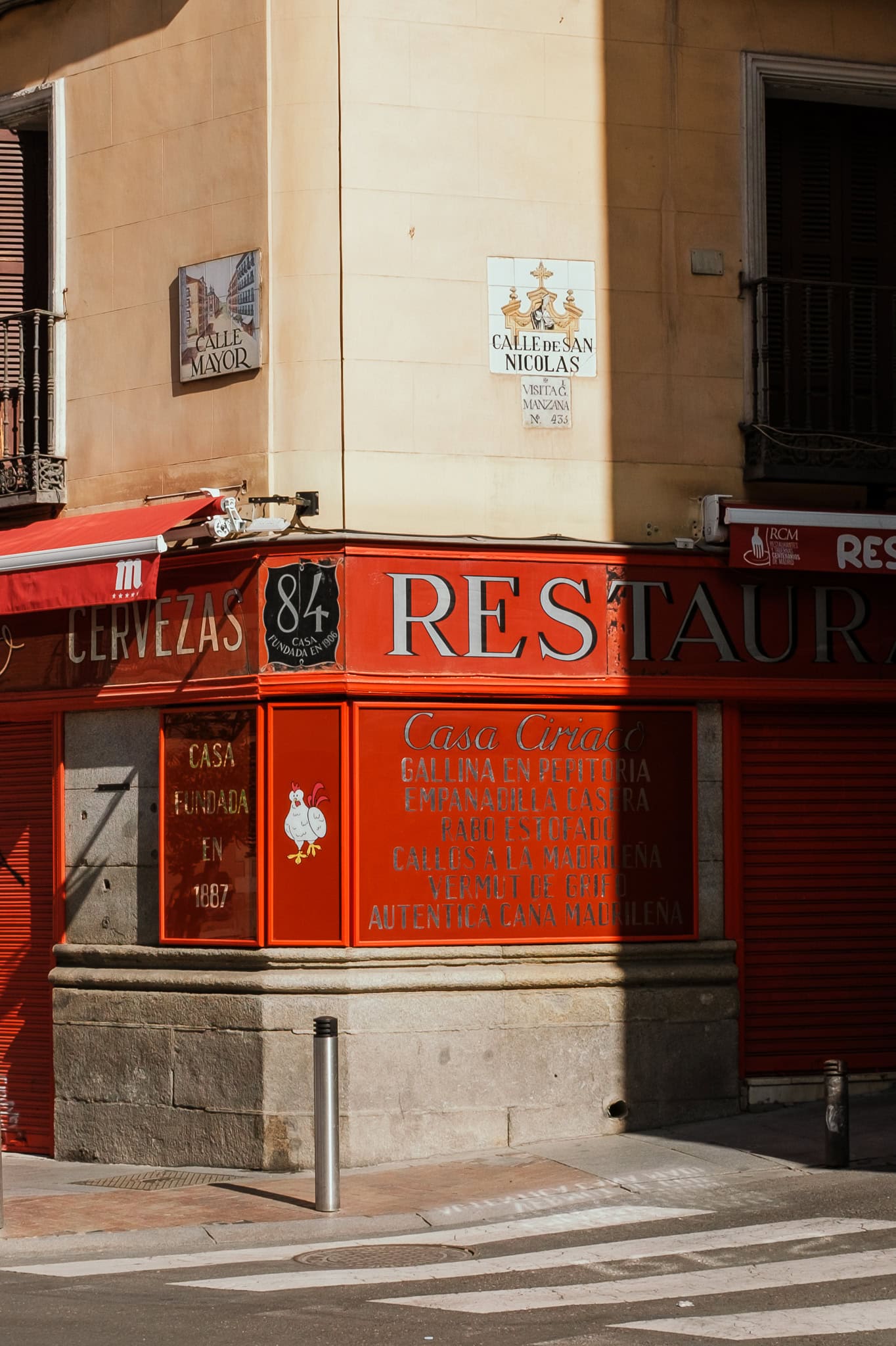 The red exterior of a restaurant, with a chicken painted on the corner.