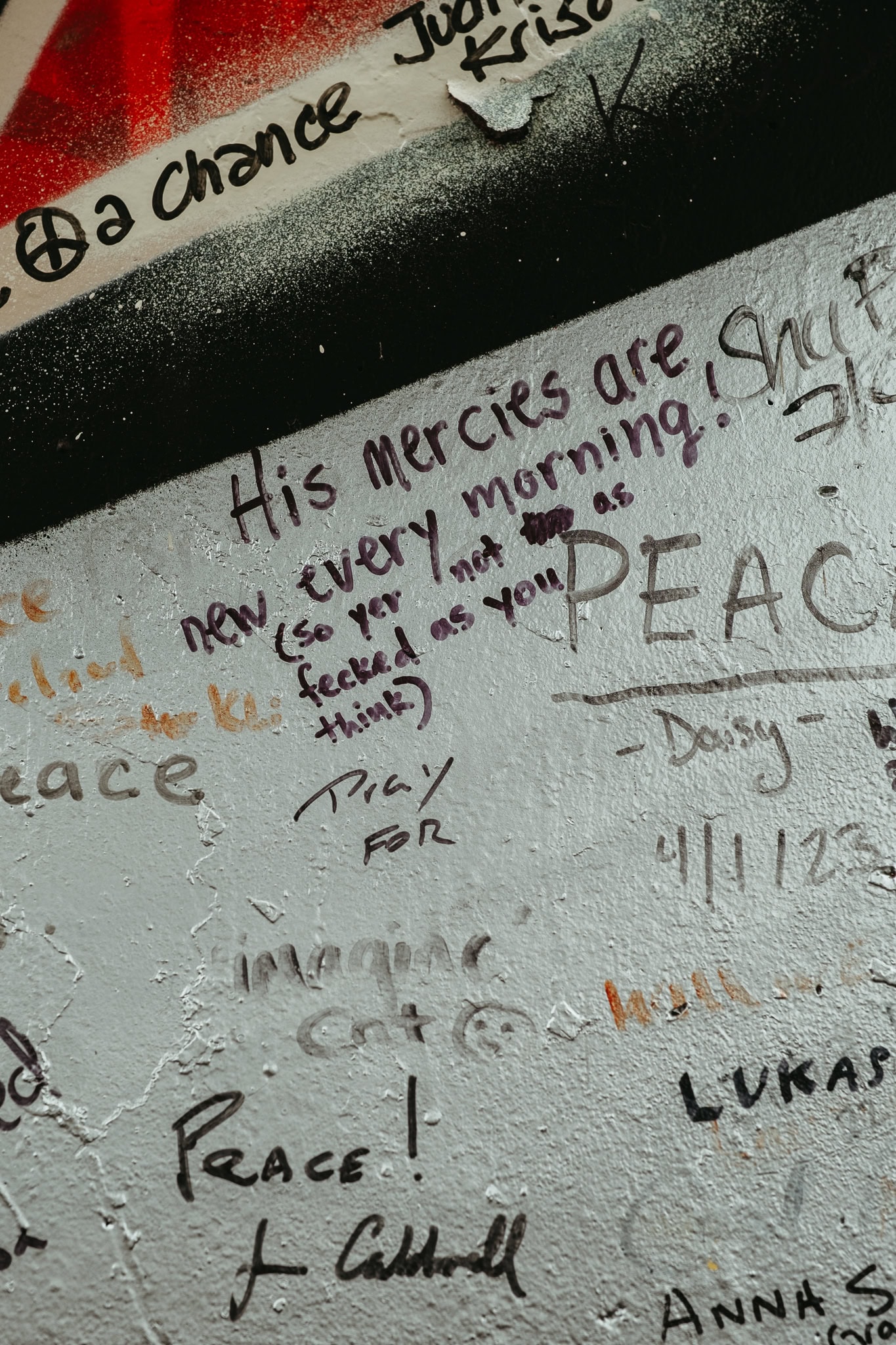 Various writings on Belfast's peace wall, including: "His mercies are new every morning! (so yer not as fecked as you think)