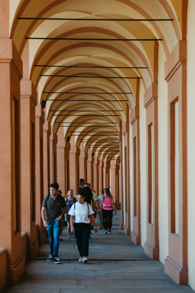 People walking under the arches of Portico di San Luca.