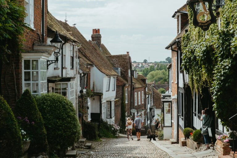 People walking on a cobblestone street with historic buildings on either side.