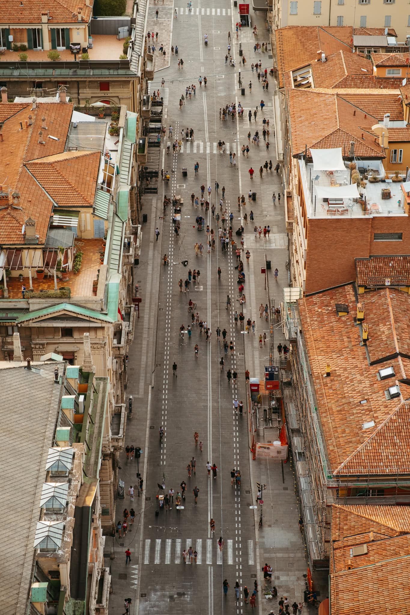 Overhead view of many people walking down a wide street.