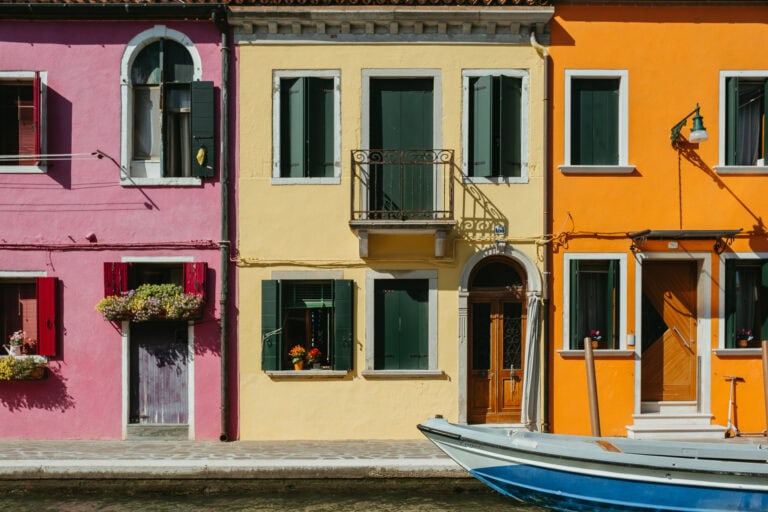 Pink, yellow, and orange houses along a canal.