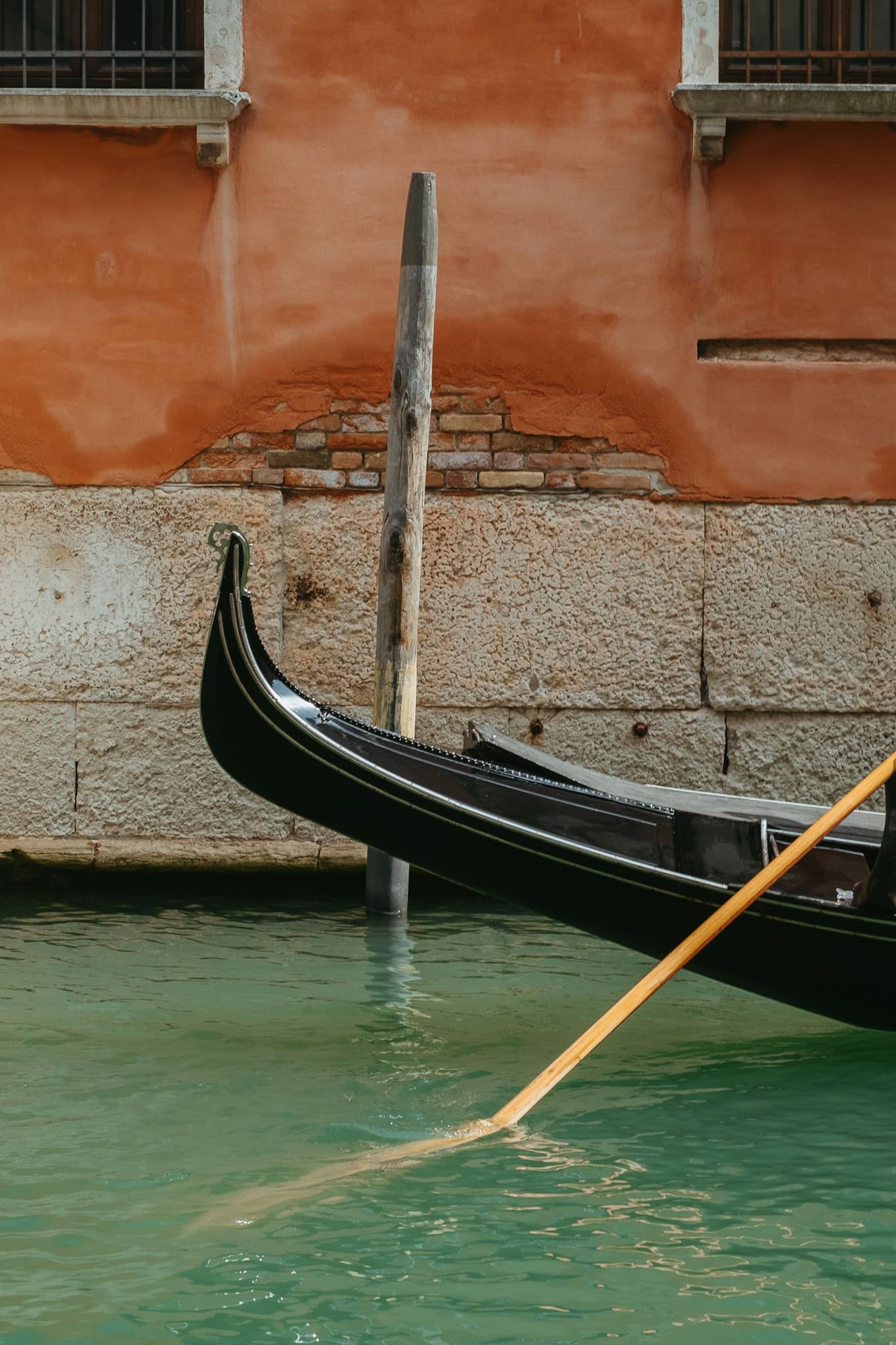 The end of a gondola on a canal.