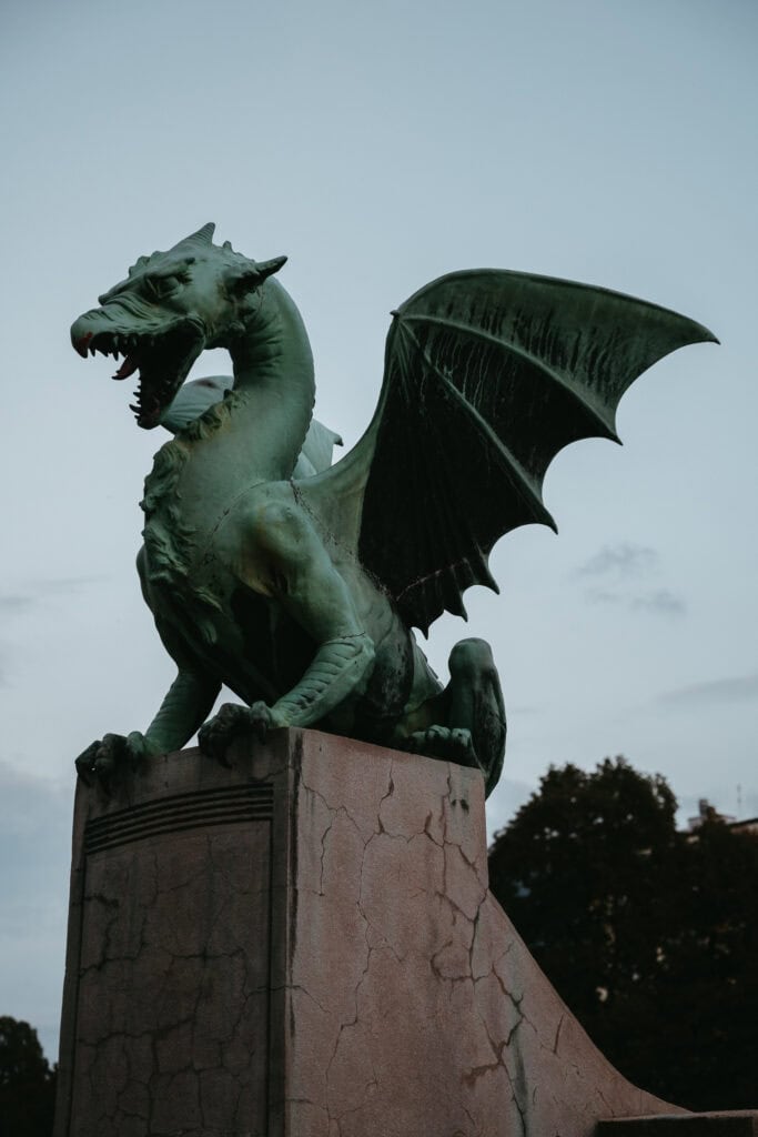 A sculpture of a dragon on a bridge.