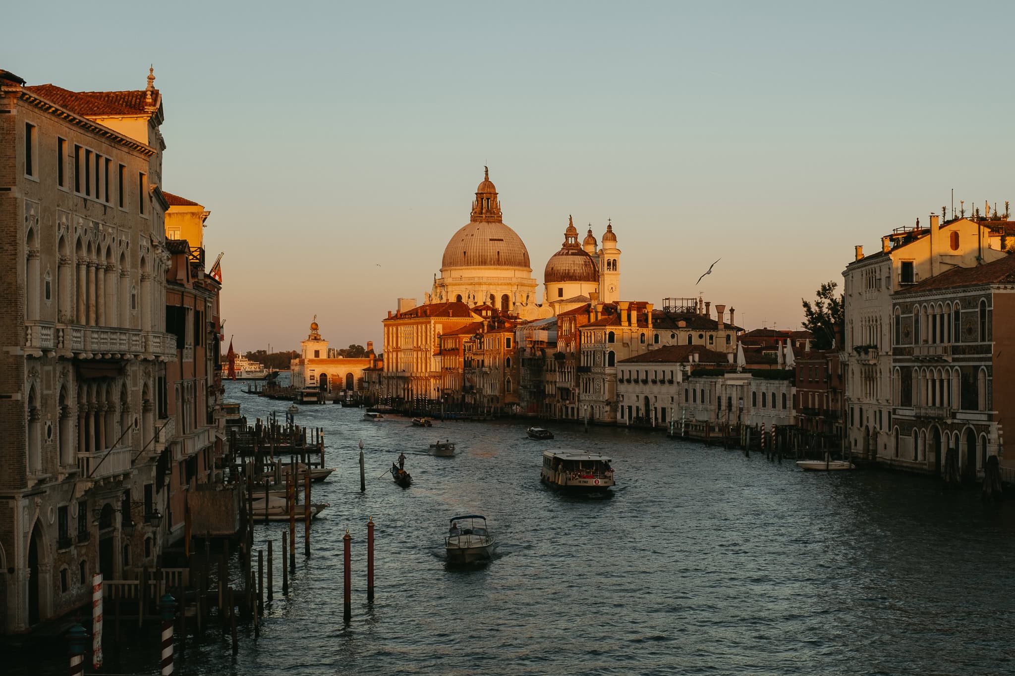 A basilica glows in the light of the setting sun at the end of the Grand Canal.
