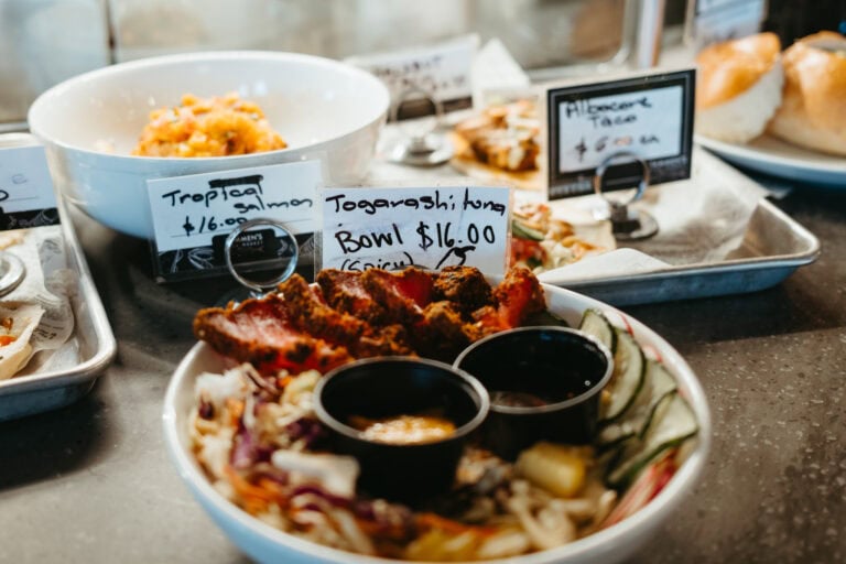 Plates of food with prices on a market stand.