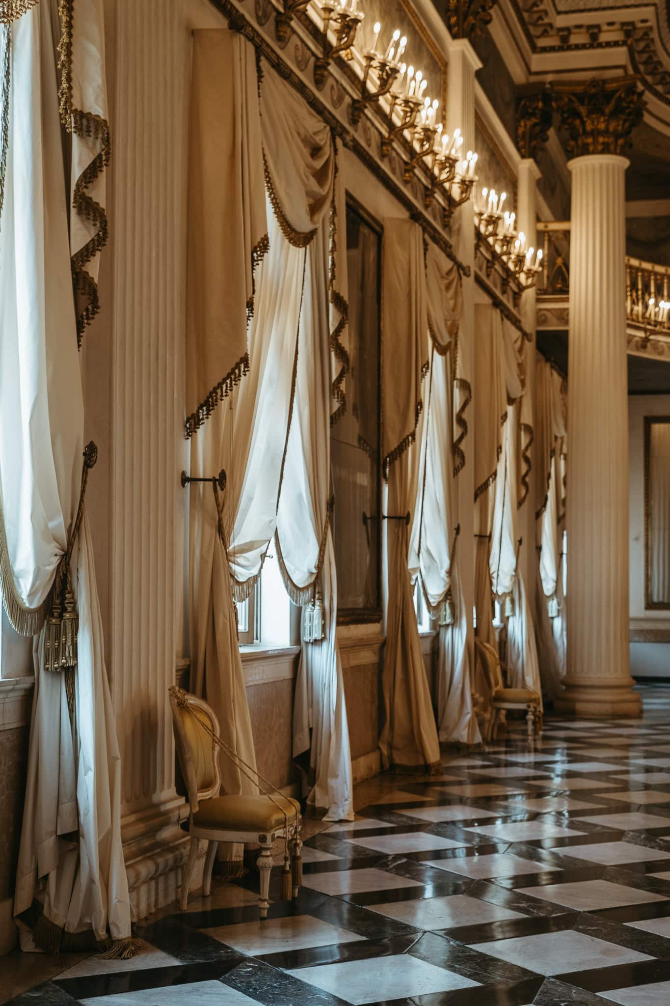 Curtains lining the windows along a ballroom.