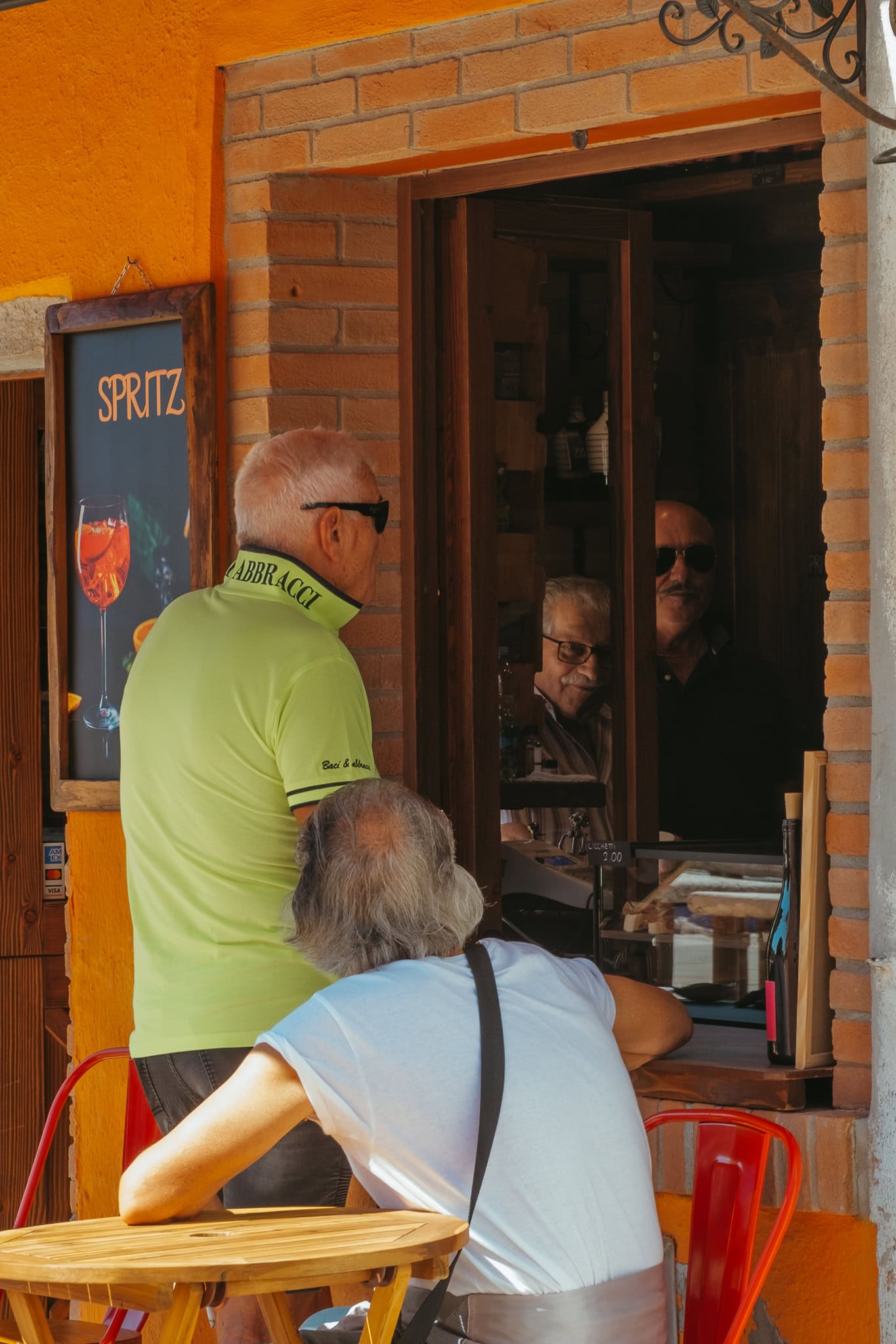 Men stand at a window advertising spritzes.