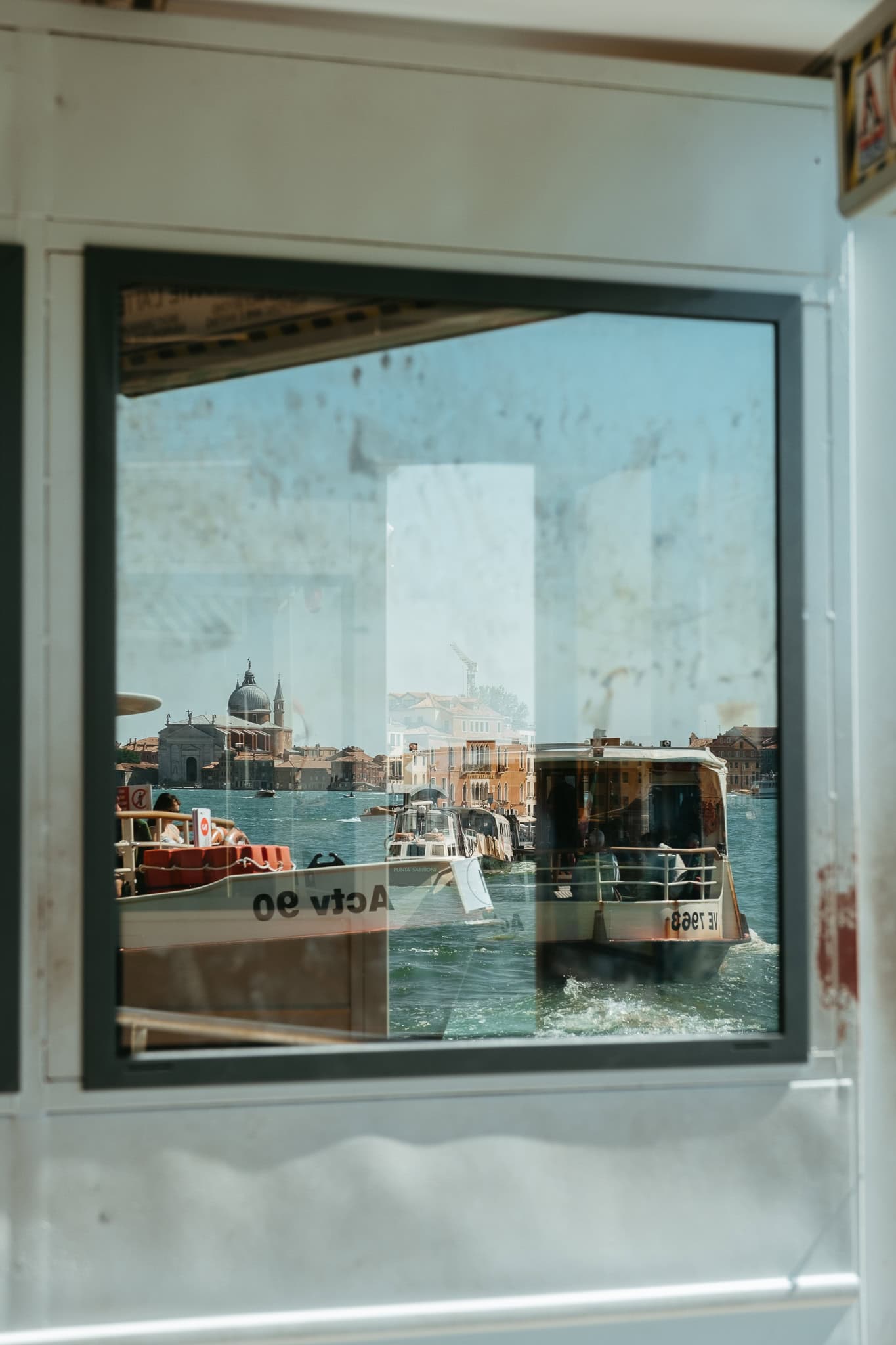 A window reflecting various boats.