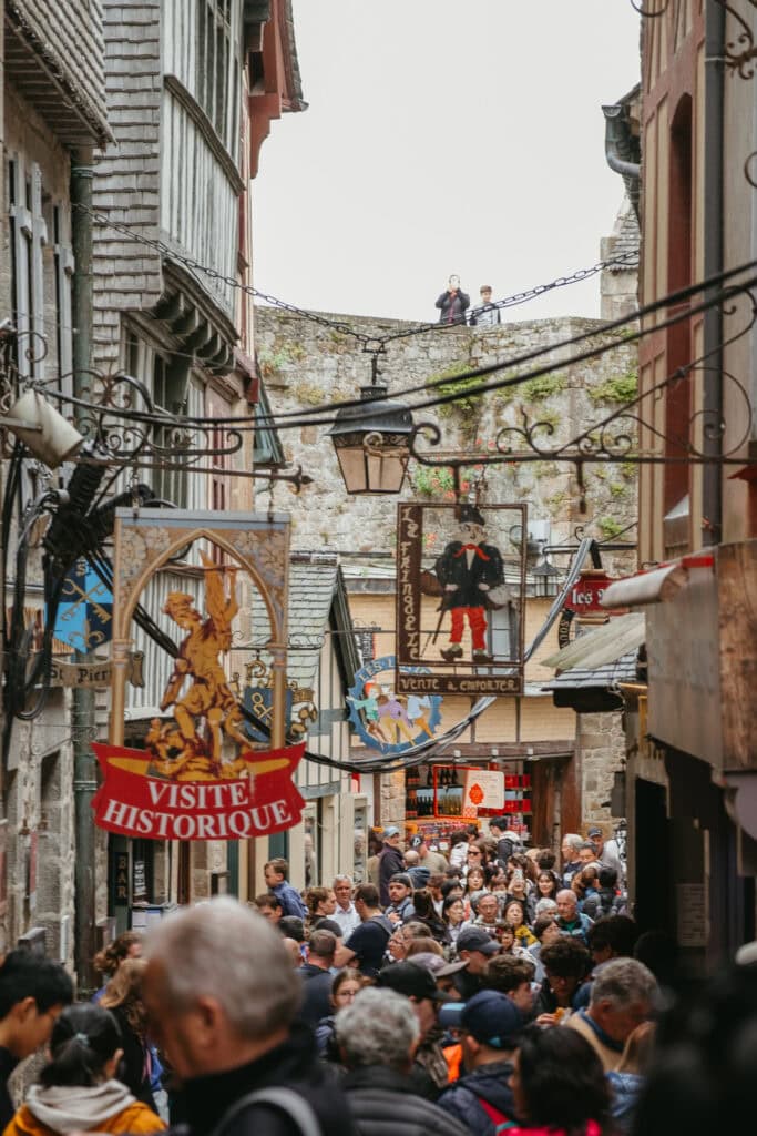 Signs hanging above a crowded street.