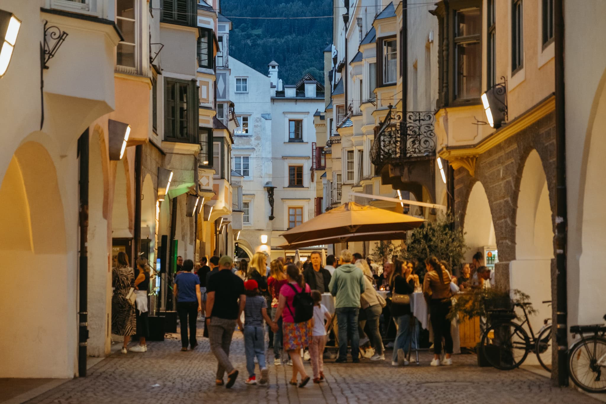 People walking through a street in the evening.