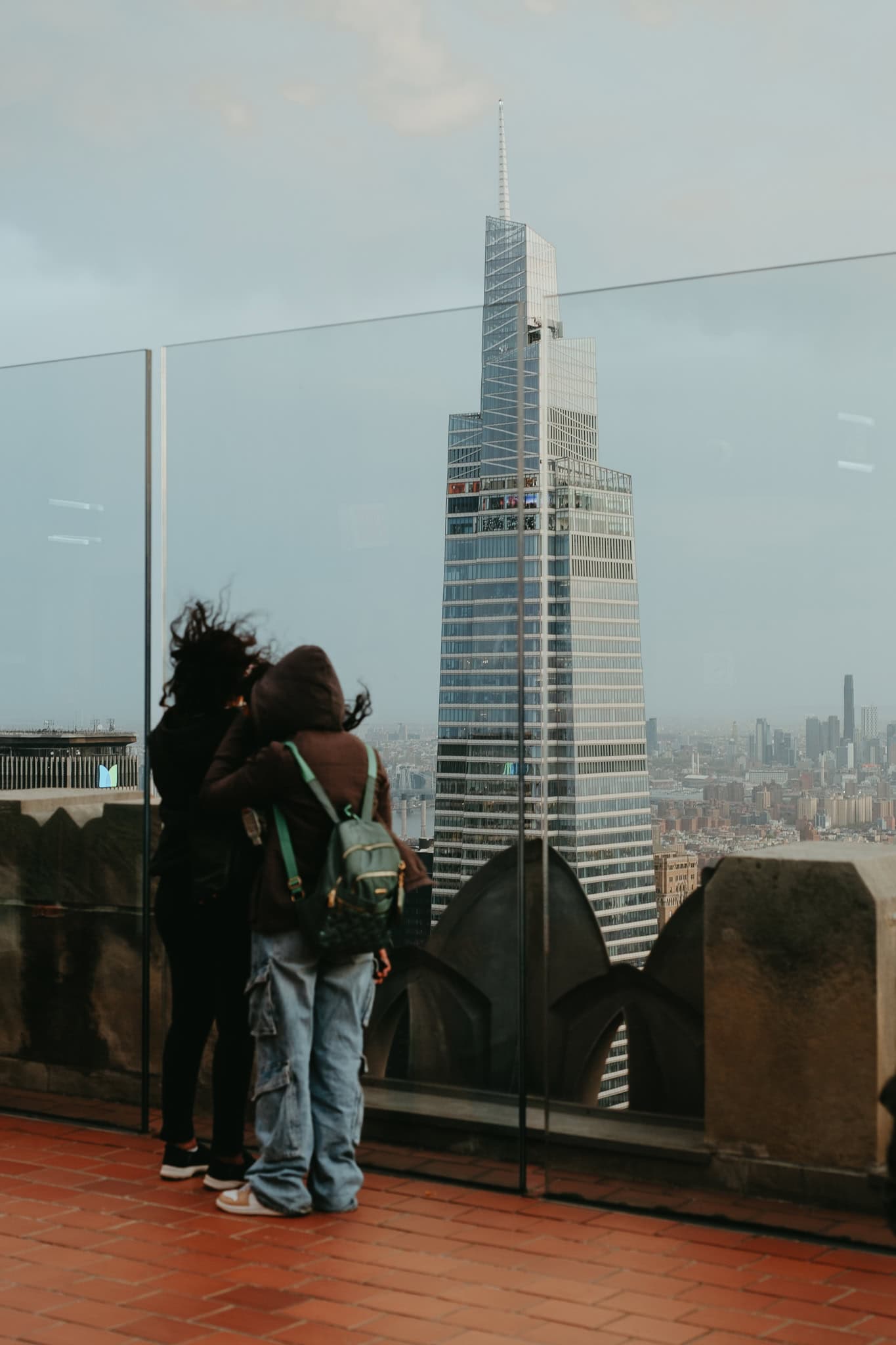 Two people looking at the views from the Top of the Rock rooftop deck.