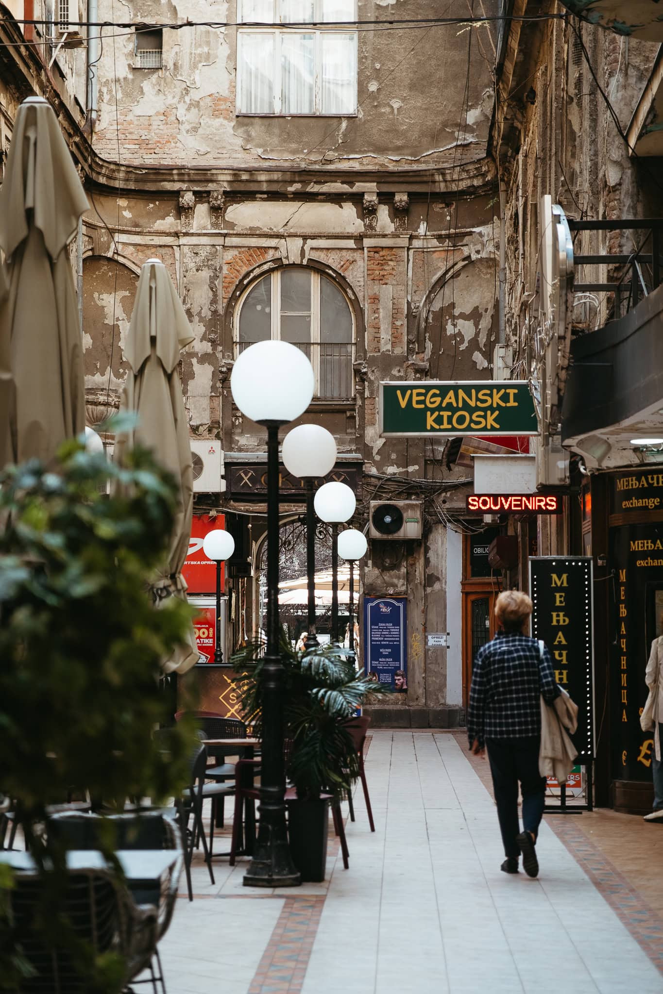 A person walks through a covered arcade.