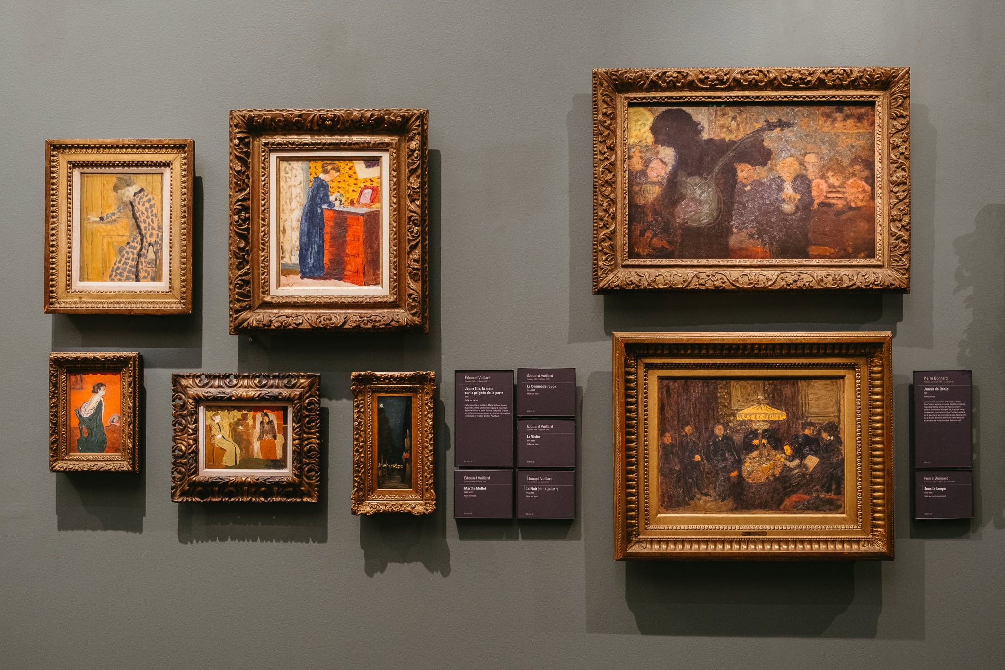 A wall full of paintings.