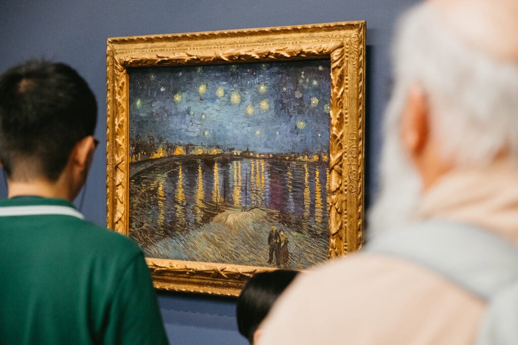 People looking at a van Gogh painting.