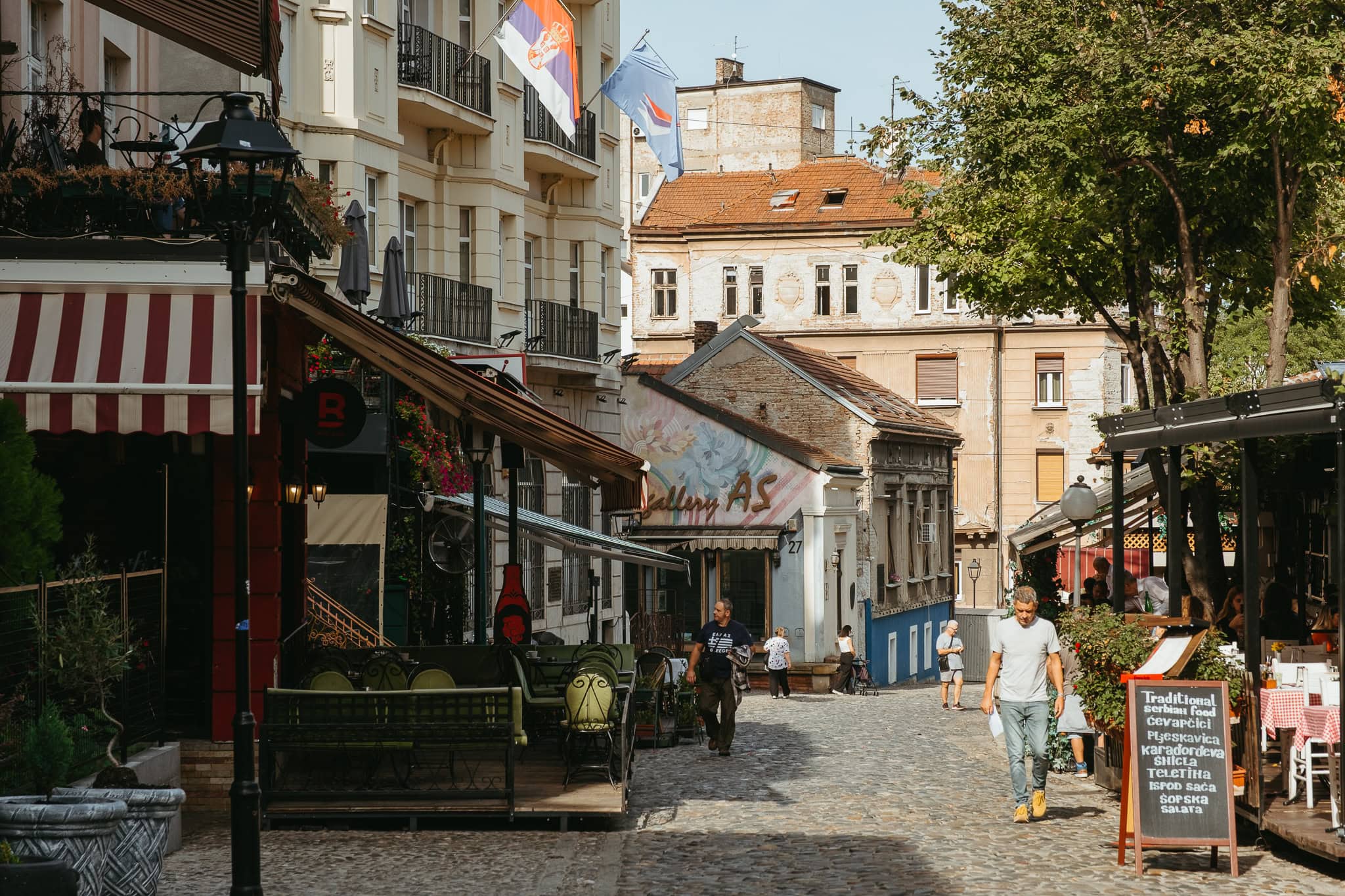 A cobblestone street lined with outdoor cafes.