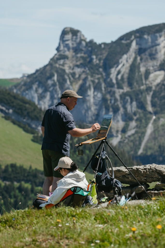 People painting landscapes with a mountain in the distance.