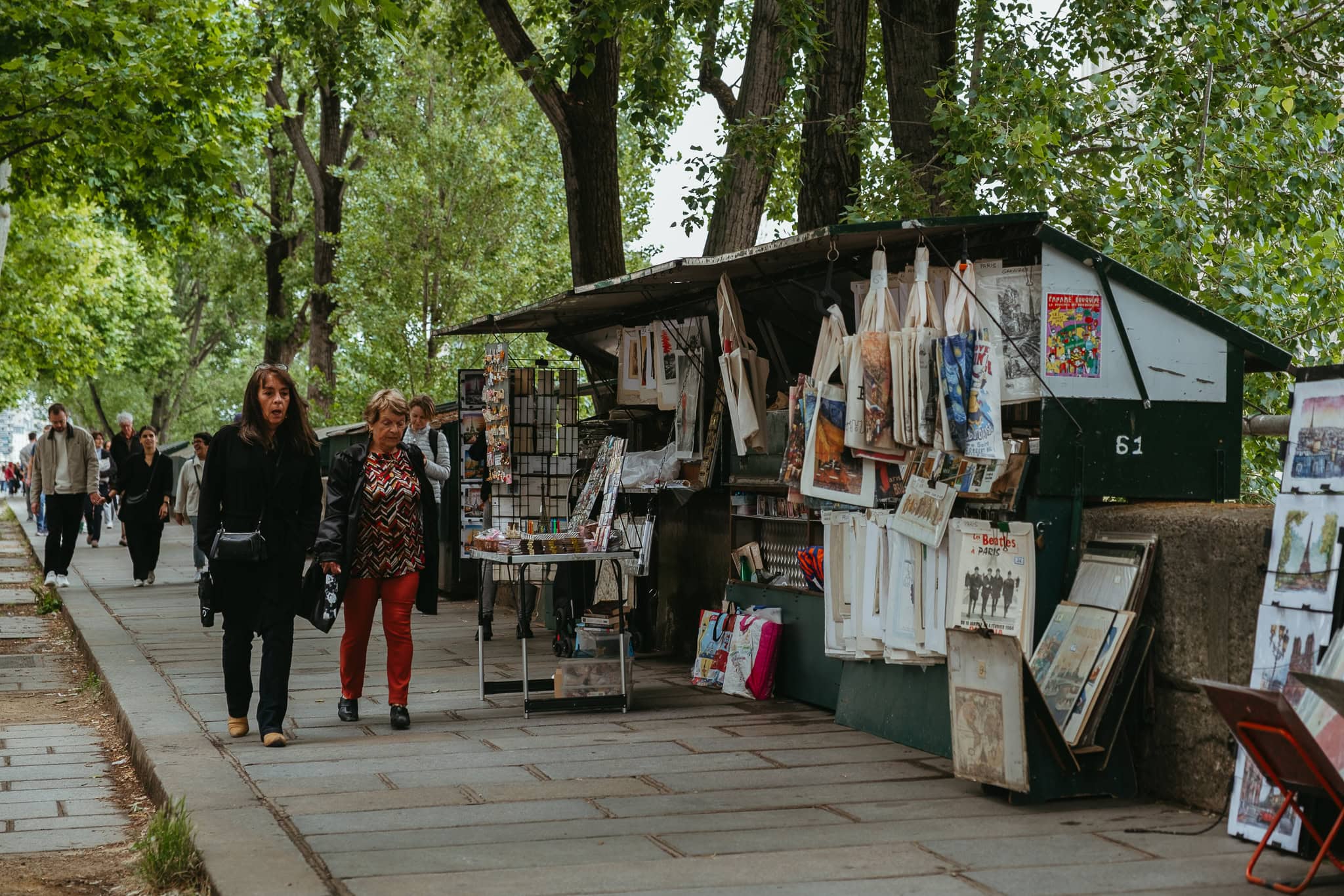 A green bouquiniste stall selling art and other wares.