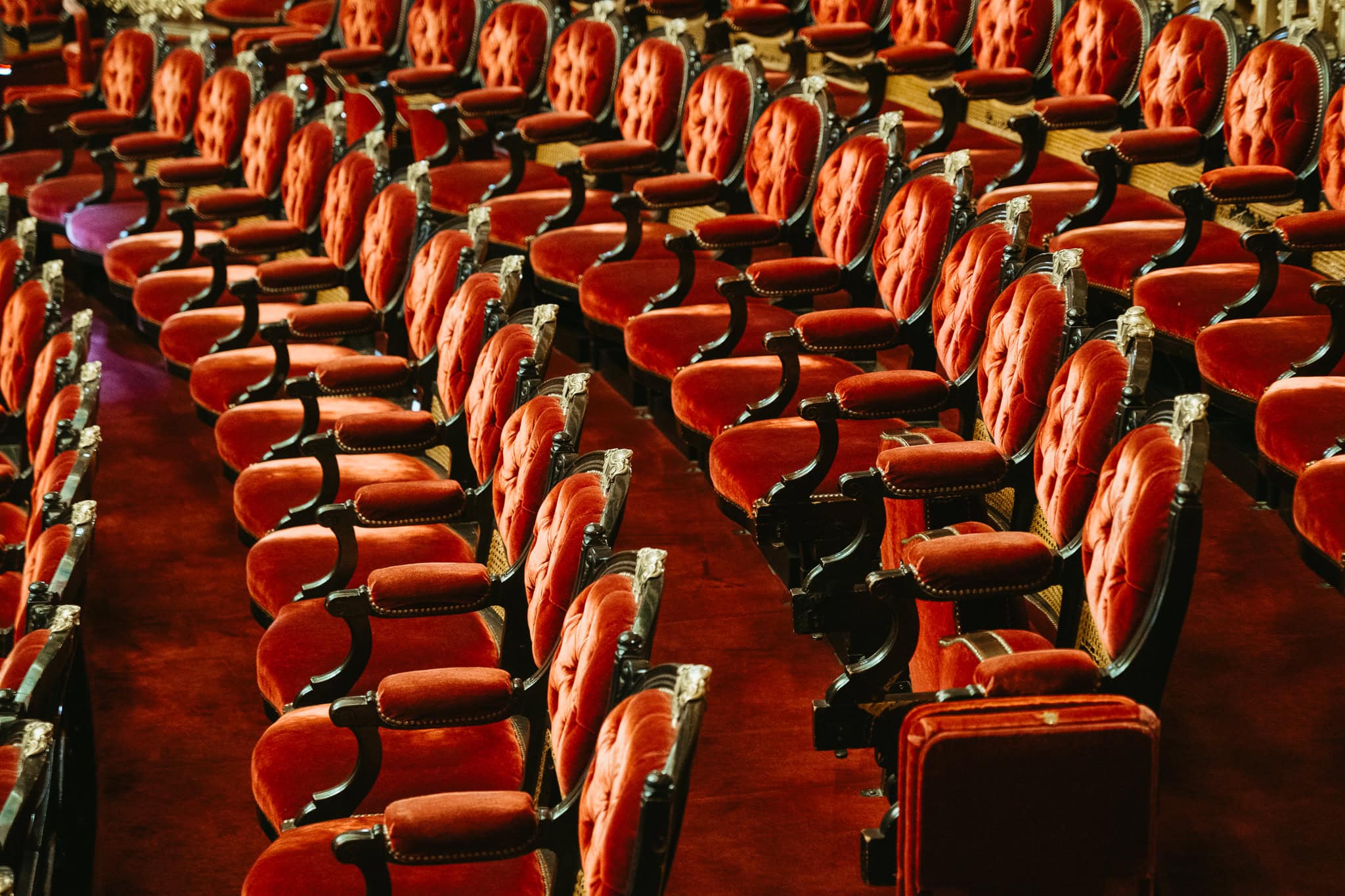 Rows of red velvet theater seats.