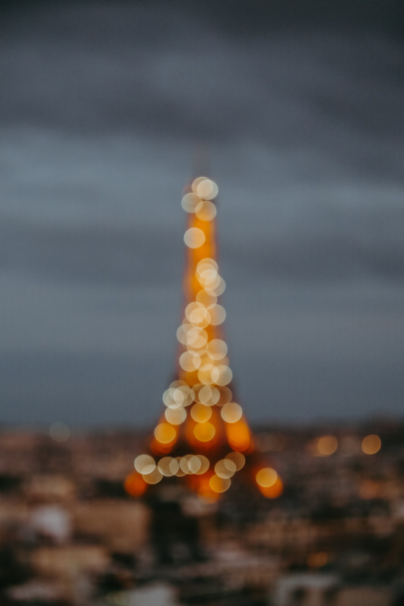 A blurred view of the Eiffel Tower sparkling at night.