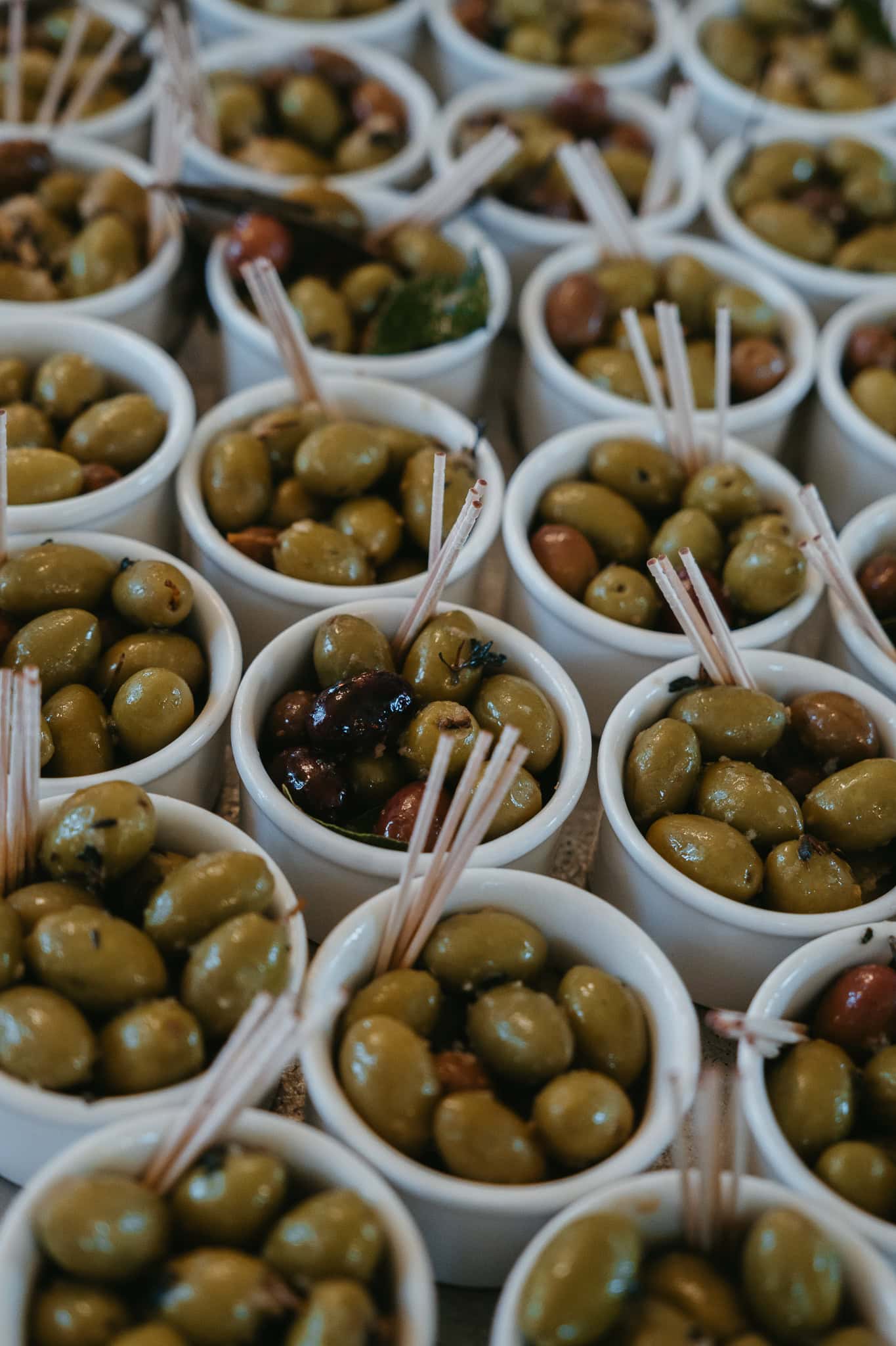A bunch of small cups of olives.