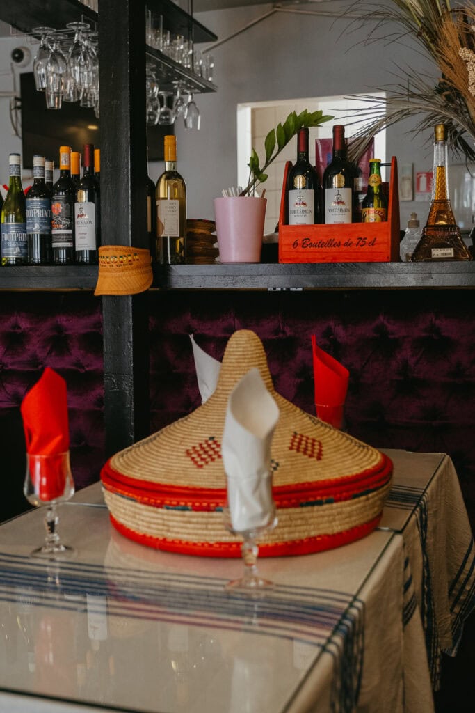 A covered straw platter sitting on a restaurant table.